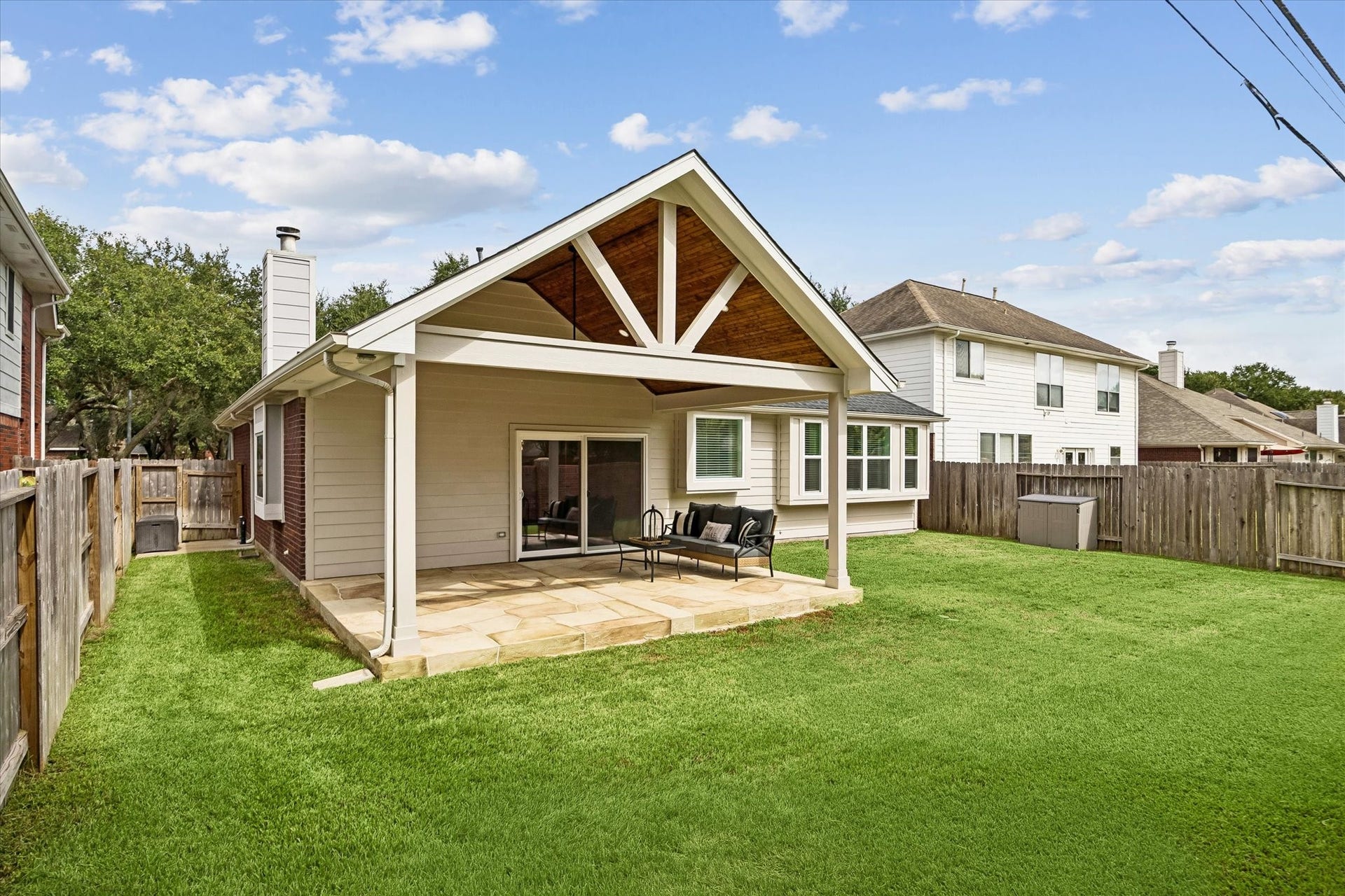 Spacious backyard showcases the impressive covered patio and plenty of green space beyond.