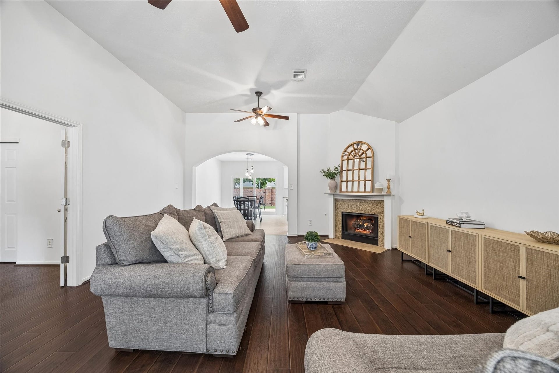 Additional living room view highlights the vaulted ceiling, fireplace and generous room for comfortable seating.