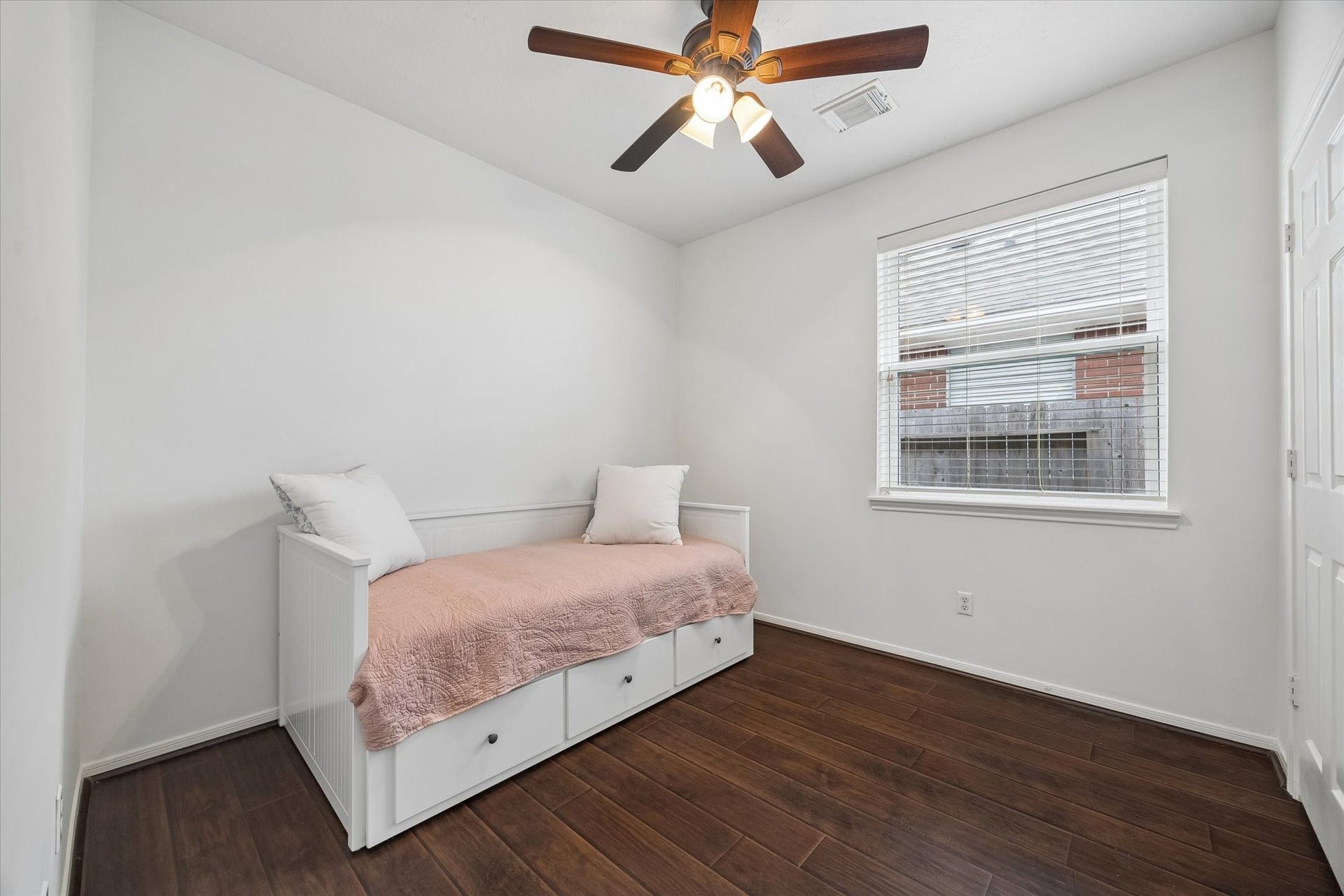 Another secondary bedroom offers wood-look flooring, ceiling fan and a comfortable amount of space.