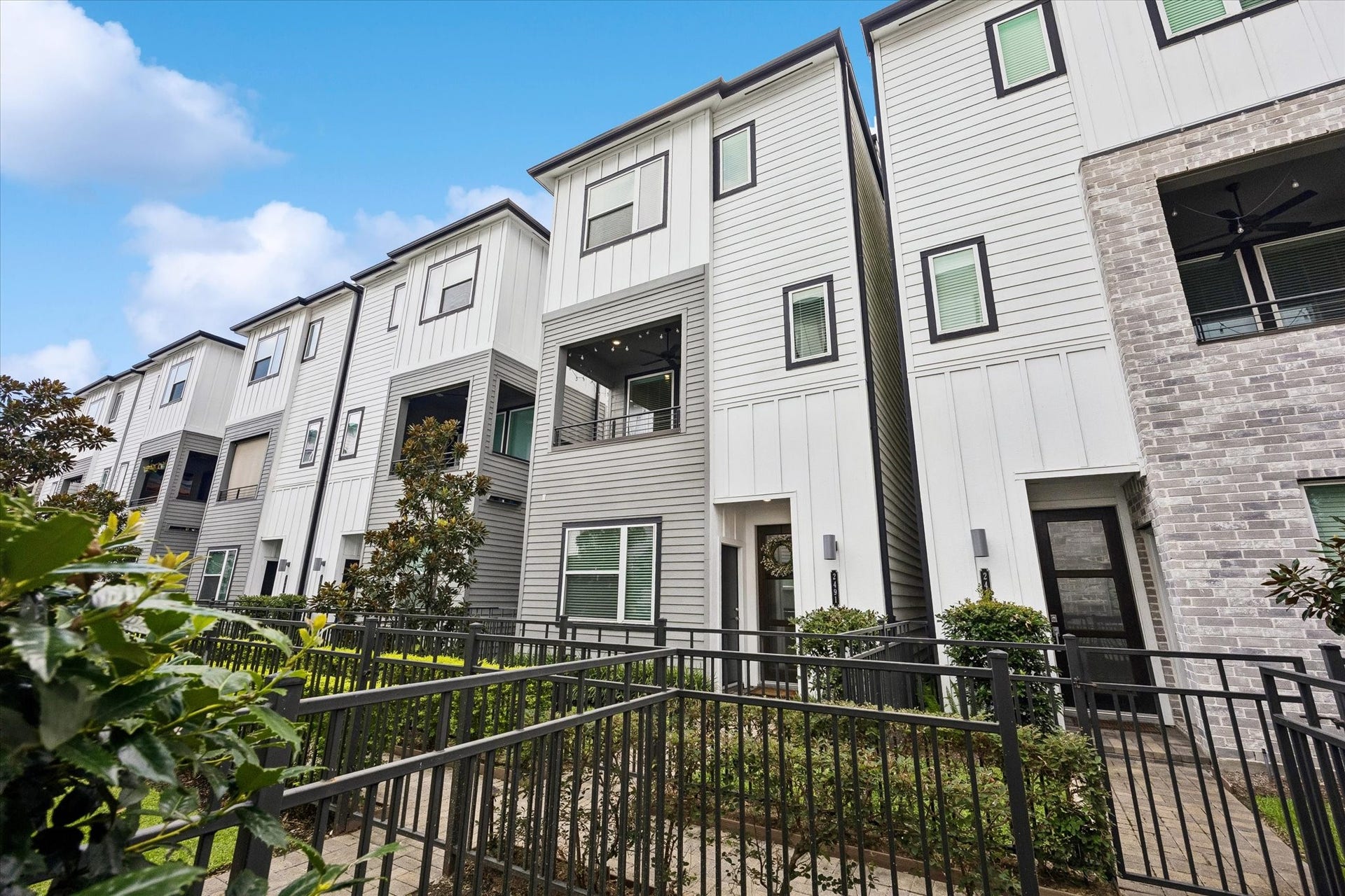 2491 W 11th Street, Houston, TX 77008 Modern exterior showcases clean architectural lines, a mix of siding and brick, and attractive contemporary finishes. A landscaped, gated walkway creates a welcoming approach to the home. Steps away from the community dog park.