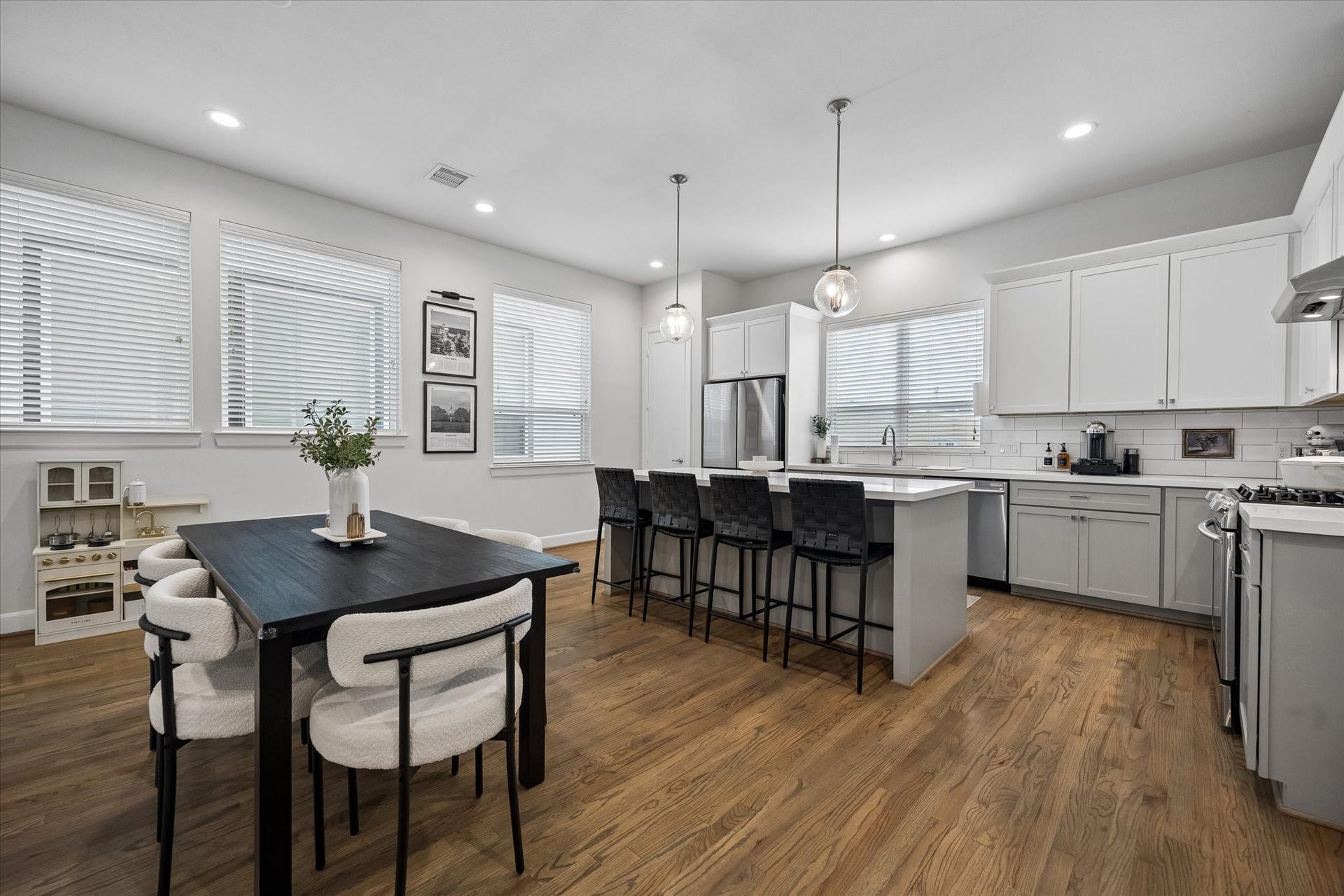 2491 W 11th Street, Houston, TX 77008 Spacious kitchen and dining area features abundant cabinetry, a large island with seating, and stainless steel appliances. Multiple windows bring excellent natural light into the space.