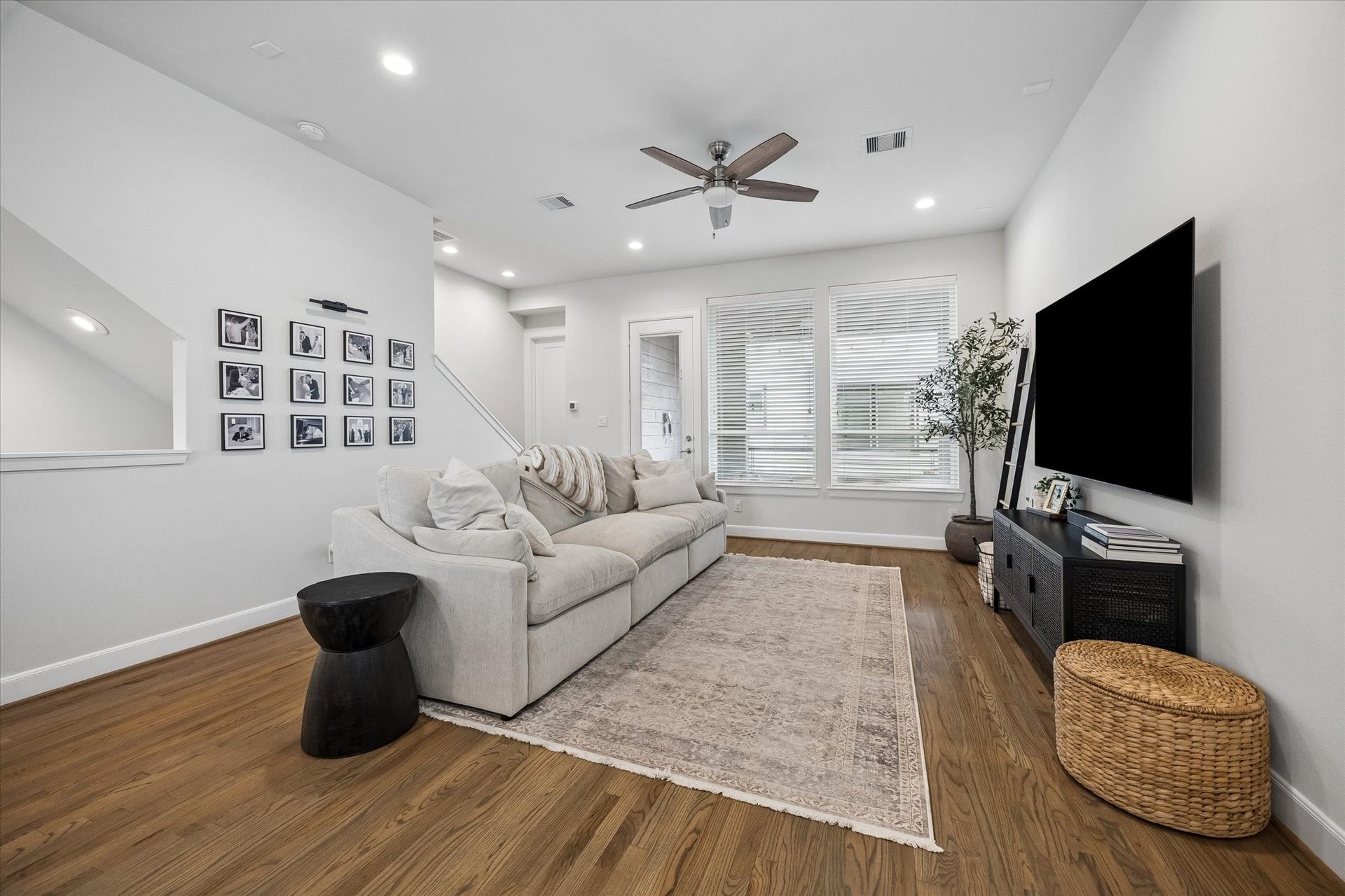 2491 W 11th Street, Houston, TX 77008 Spacious living room offers hardwood flooring, recessed lighting, and abundant natural light. The open layout provides plenty of room for comfortable everyday living and entertaining.