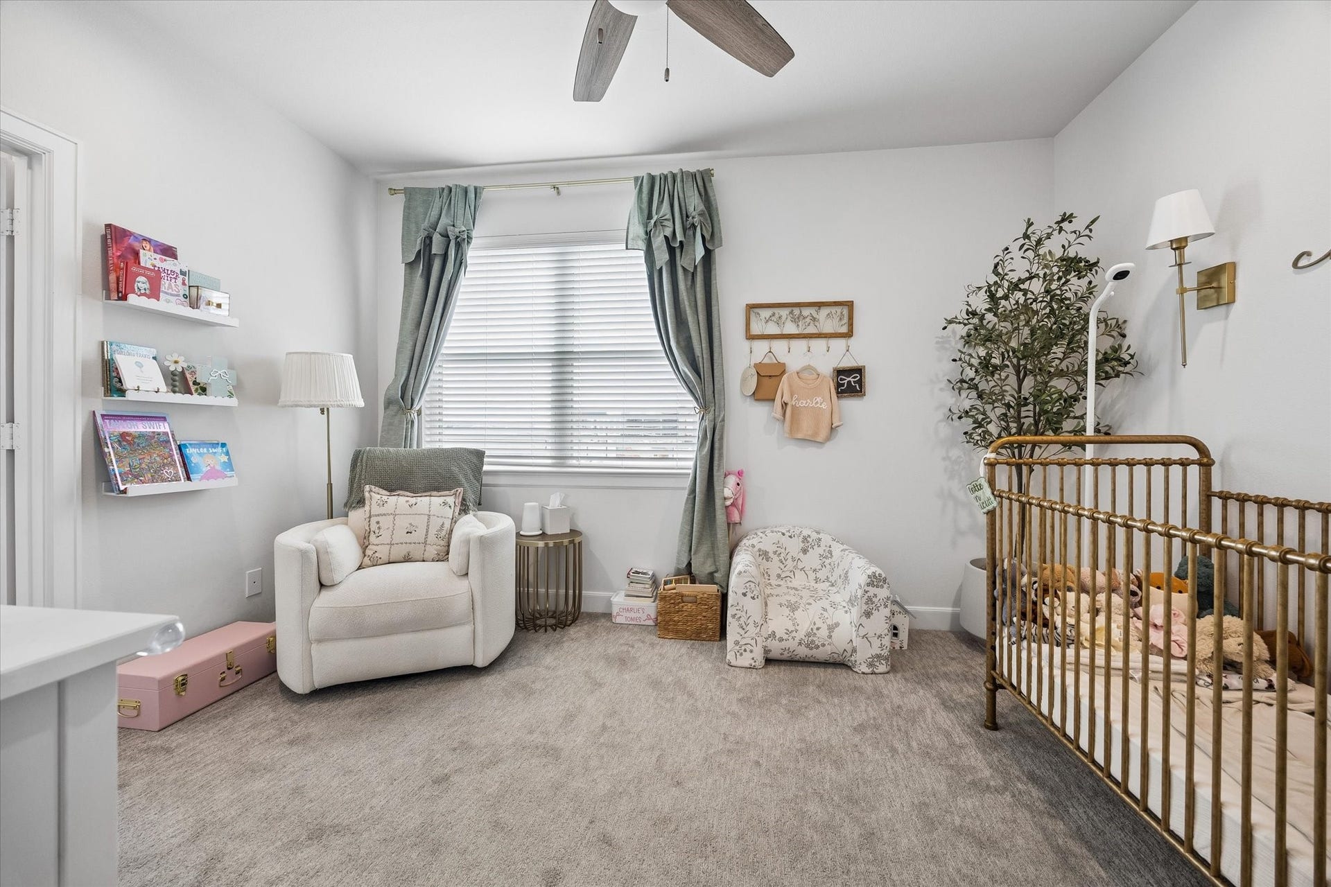 2491 W 11th Street, Houston, TX 77008 Spacious secondary bedroom is currently styled as a nursery and offers plenty of room for multiple furniture arrangements. A large window, ceiling fan, and neutral carpeting complete the space.