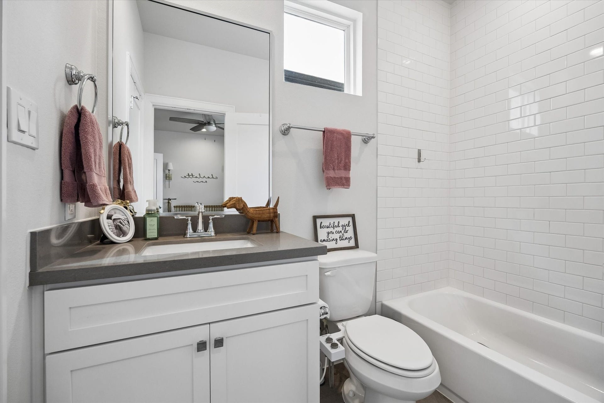 2491 W 11th Street, Houston, TX 77008 Secondary bath features a white vanity with generous counter space and a tub/shower combination surrounded by classic white subway tile. A high window adds natural light while maintaining privacy.
