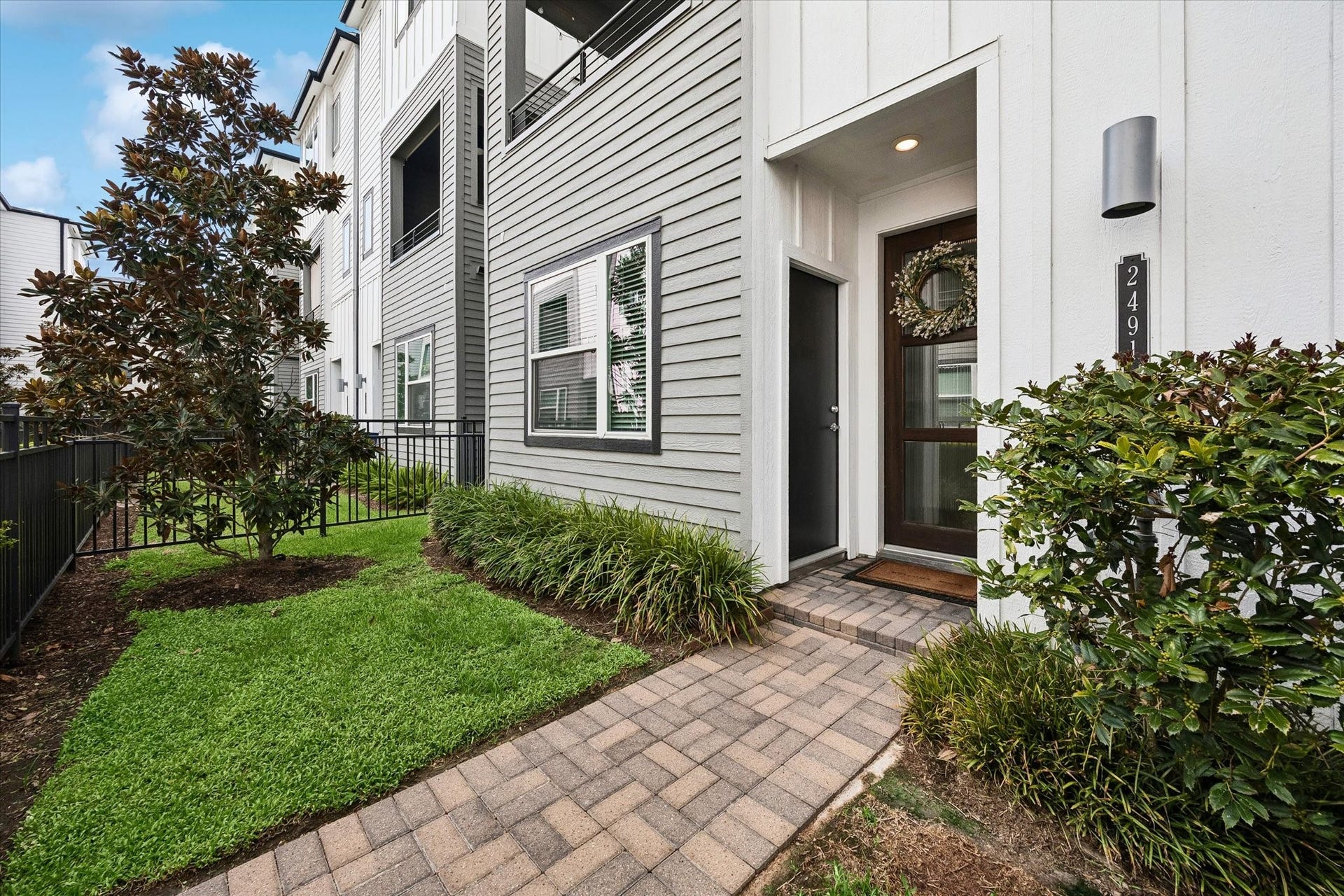 2491 W 11th Street, Houston, TX 77008 Private front entrance is surrounded by mature landscaping and a neatly maintained green space. A paver walkway leads directly to the covered entry.
