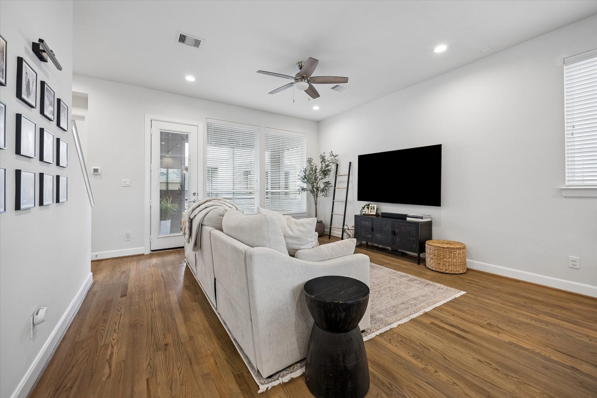 2491 W 11th Street, Houston, TX 77008 Another view of the living room highlights its generous proportions and large windows. Hardwood floors and neutral finishes provide a versatile backdrop for a variety of dcor styles.