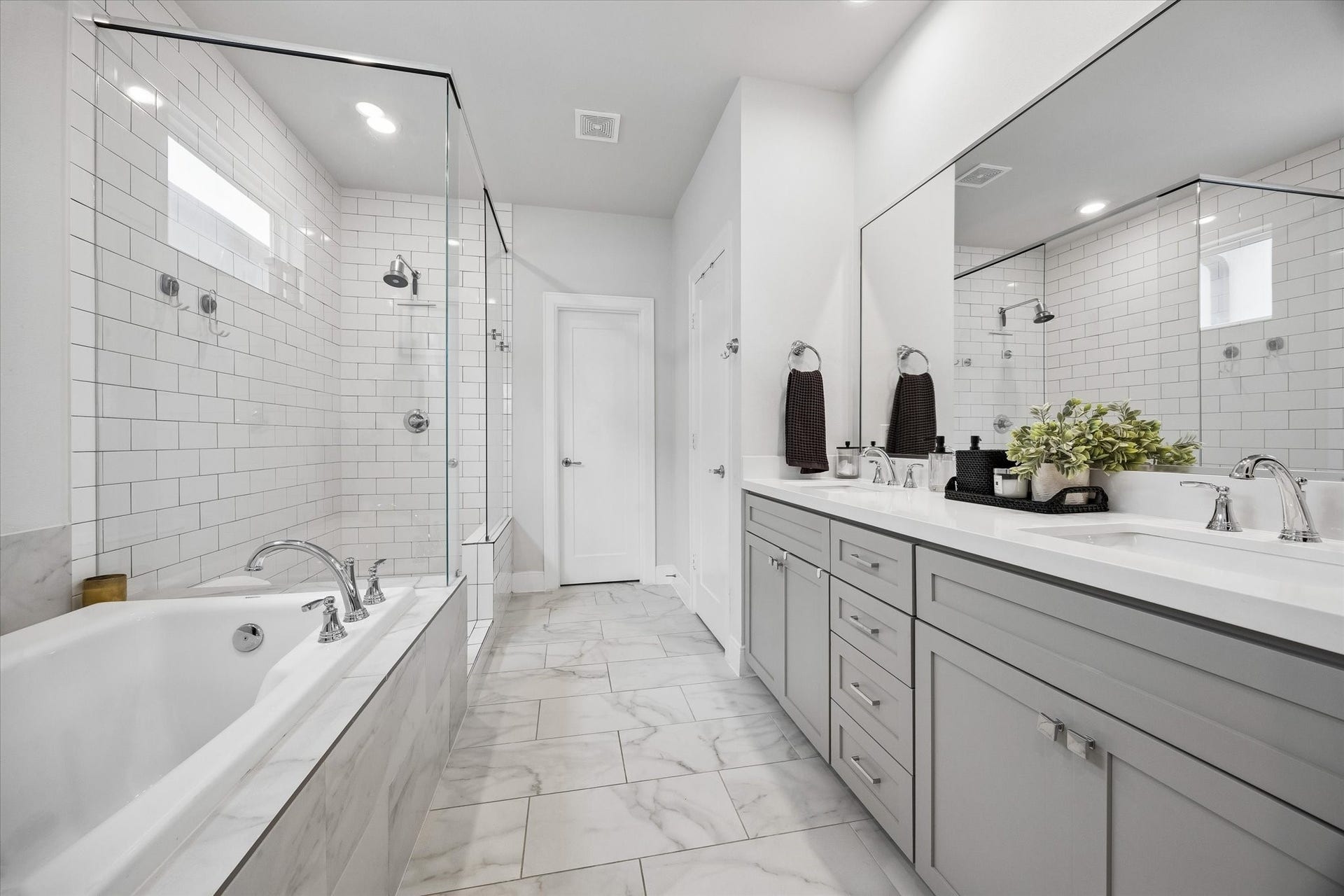 2491 W 11th Street, Houston, TX 77008 Another view of the primary bath showcases the oversized glass-enclosed shower and long dual vanity. A wall-spanning mirror enhances the bright and spacious feel.