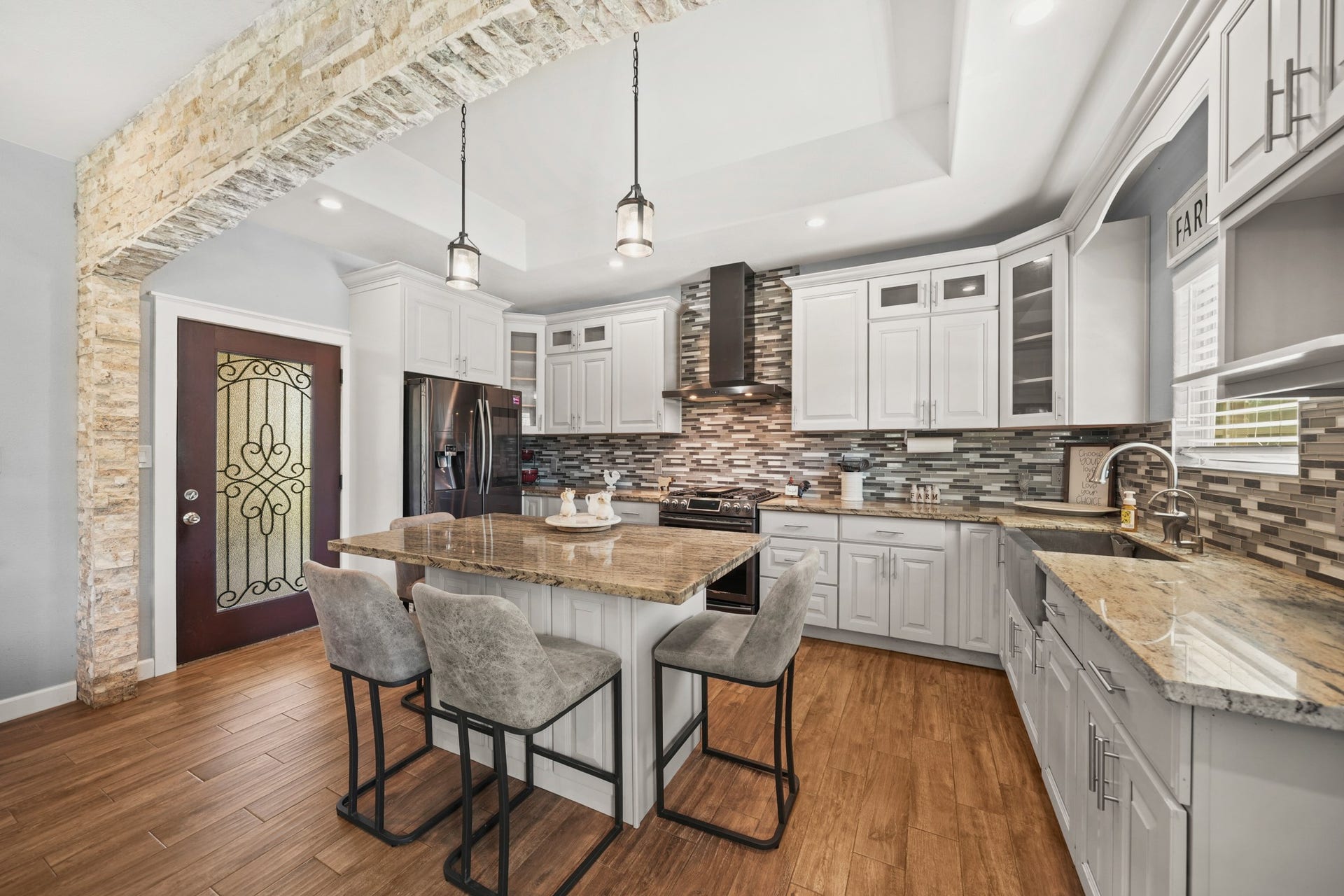 11021 32nd Street, Santa Fe, TX 77510 Kitchen Island: Highlights the granite seating area and the front door context