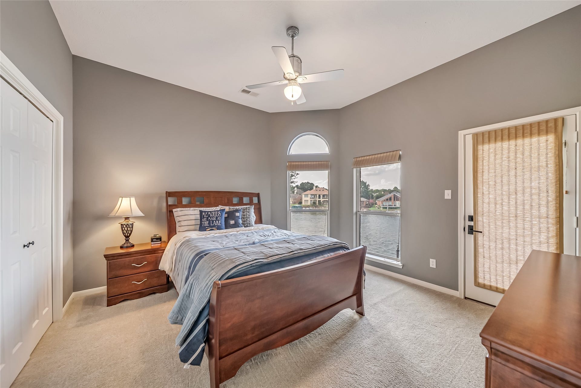 318 Bayshore Drive, Montgomery, TX 77356 Bedroom 3 offers a spacious and inviting retreat with large windows that frame peaceful lake views and fill the room with natural light. A private door opens directly onto the wraparound balcony, creating a seamless indoor-outdoor connection and the perfect place to enjoy the waterfront setting from the comfort of your own room.