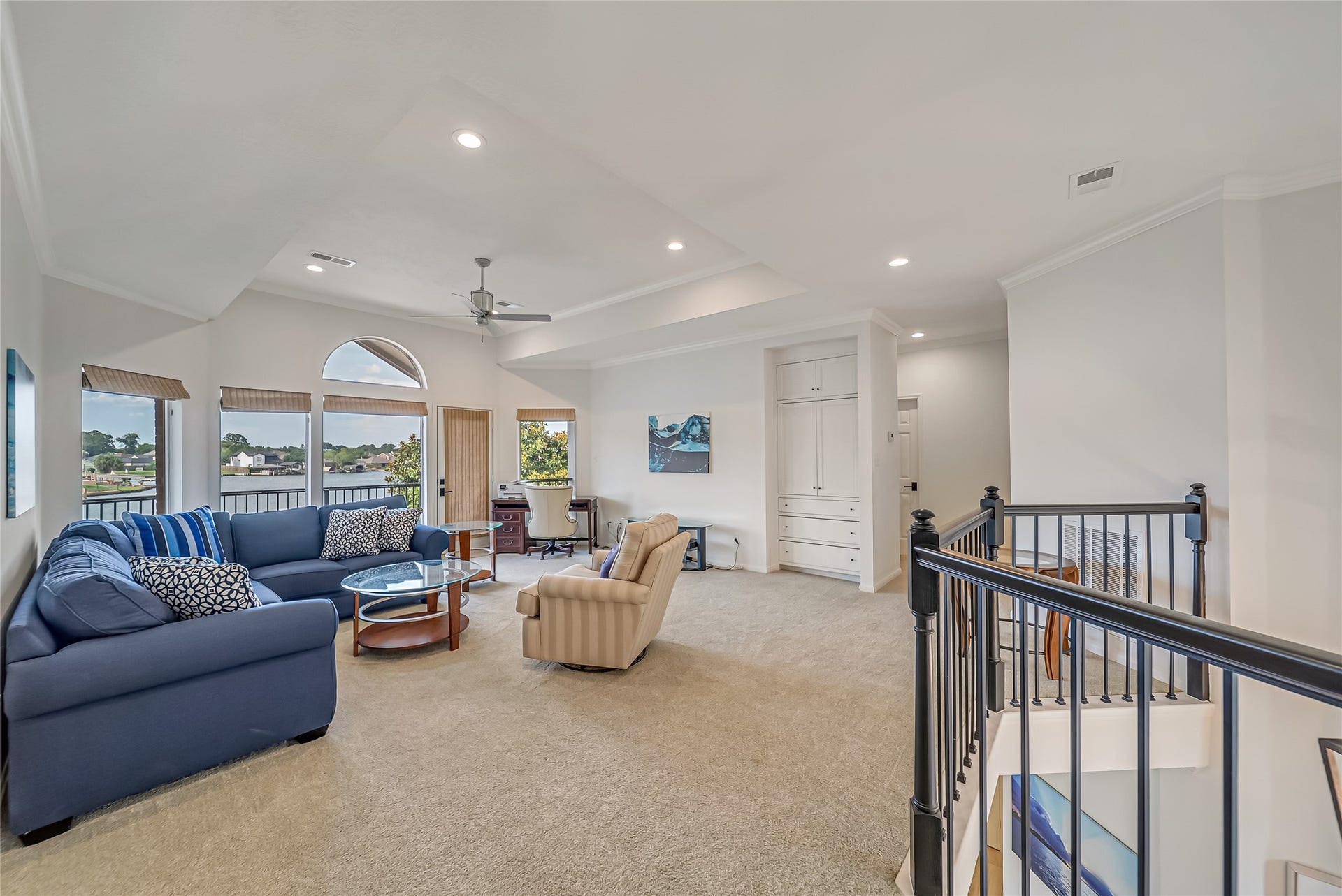 318 Bayshore Drive, Montgomery, TX 77356 The expansive second-floor game/flex room features an elegant tray ceiling, custom built-in cabinetry for additional storage, and large windows that fill the space with natural light. Direct access to the wraparound balcony creates the perfect place to enjoy the lake views, while the game room seamlessly connects to the remaining three bedrooms, a full bathroom, and convenient attic storage.