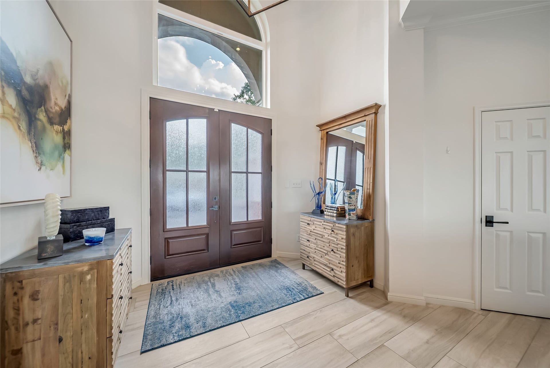 318 Bayshore Drive, Montgomery, TX 77356 Step inside to an inviting foyer where expansive windows bathe the space in natural light, creating a bright and elegant first impression while showcasing the updated wood-grain tile flooring that flows throughout the first floor.