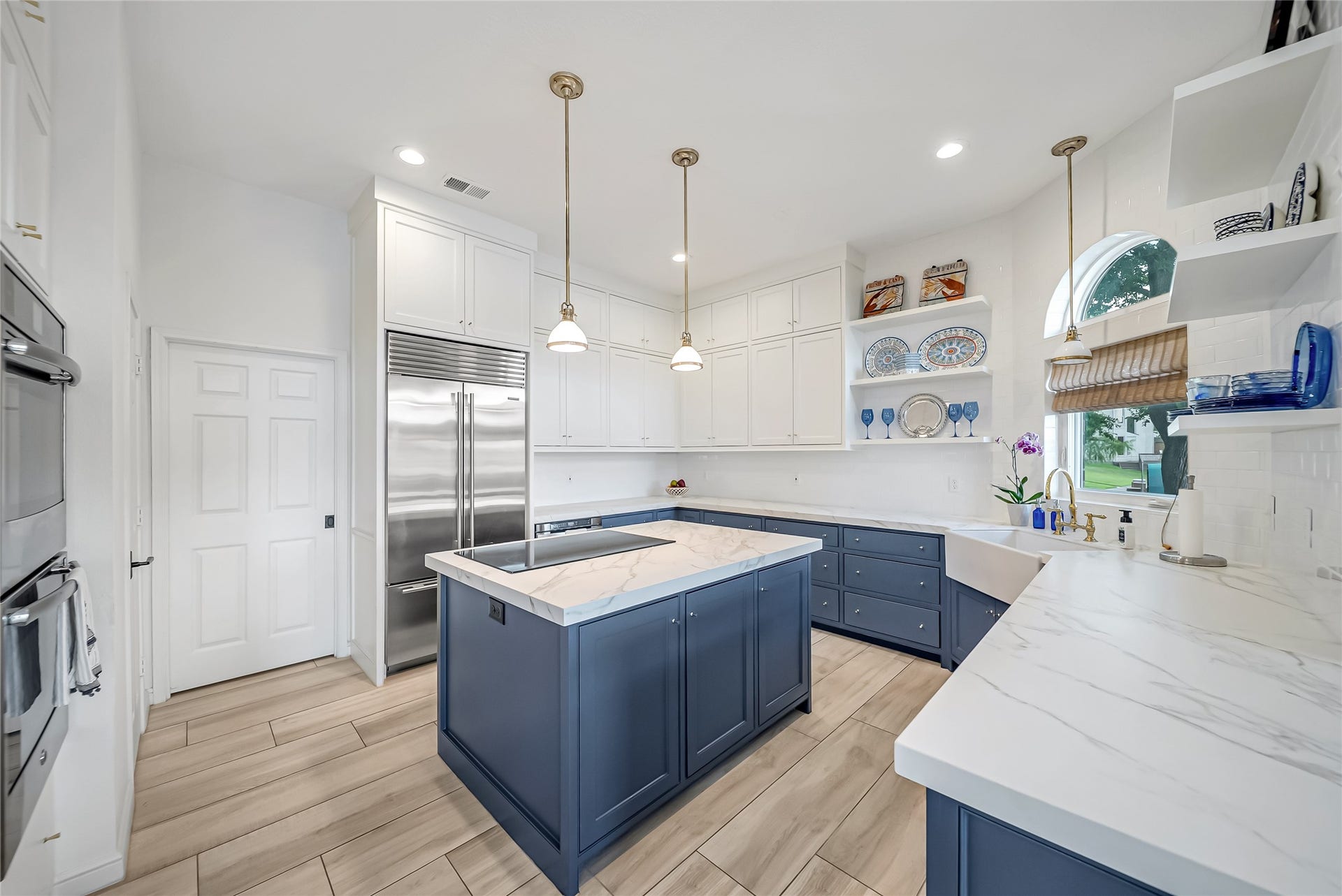 318 Bayshore Drive, Montgomery, TX 77356 Beautifully remodeled, the kitchen showcases elegant two-tone custom cabinetry, Neolith countertops, premium stainless steel appliances, a farmhouse sink, designer lighting, and an oversized island that serves as the heart of the home.