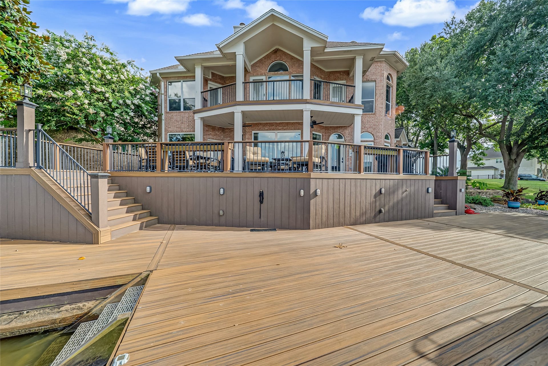318 Bayshore Drive, Montgomery, TX 77356 Expansive TREX deck with dual staircase access provides seamless entry from both sides, leading to a private dock for effortless waterfront living. Above, the wraparound balcony offers panoramic lake views, creating the perfect setting for entertaining or relaxing by the water.