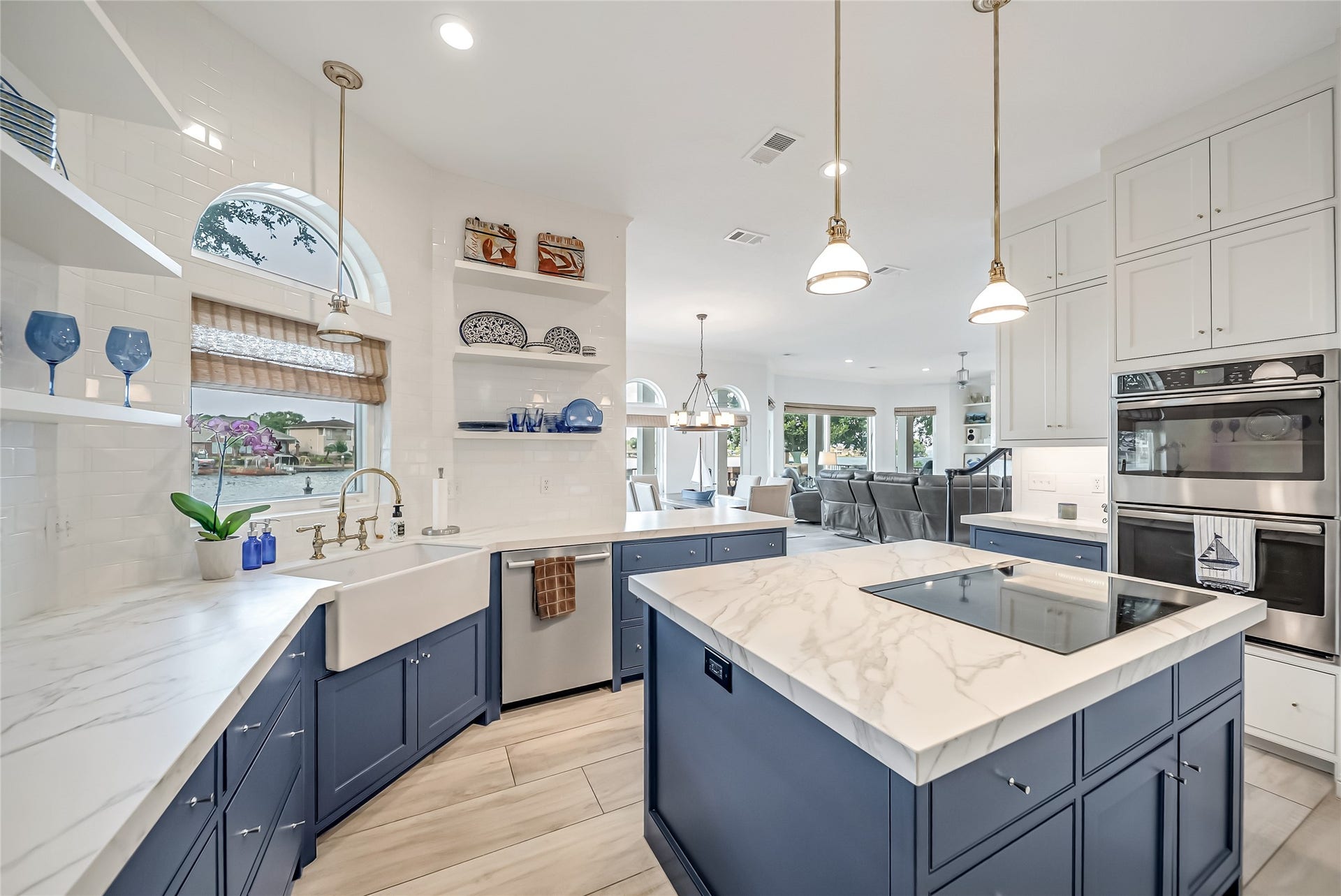 318 Bayshore Drive, Montgomery, TX 77356 Enjoy preparing meals with tranquil lake views from the farmhouse sink, while custom open shelving, double ovens, and an oversized island with a built-in cooktop create a kitchen designed for both everyday living and effortless entertaining.