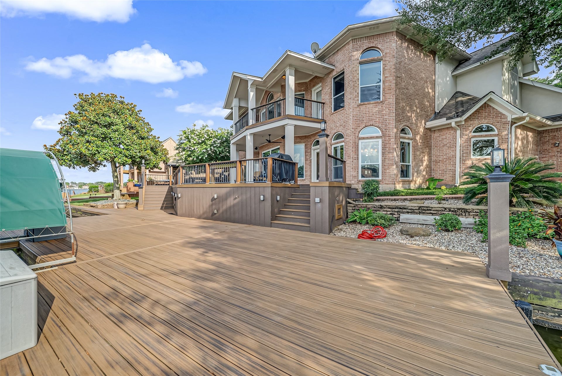 318 Bayshore Drive, Montgomery, TX 77356 From its stately columns to its thoughtfully designed multi-level exterior, the rear elevation offers exceptional curb appeal from the water while showcasing the home's impressive craftsmanship and timeless design.