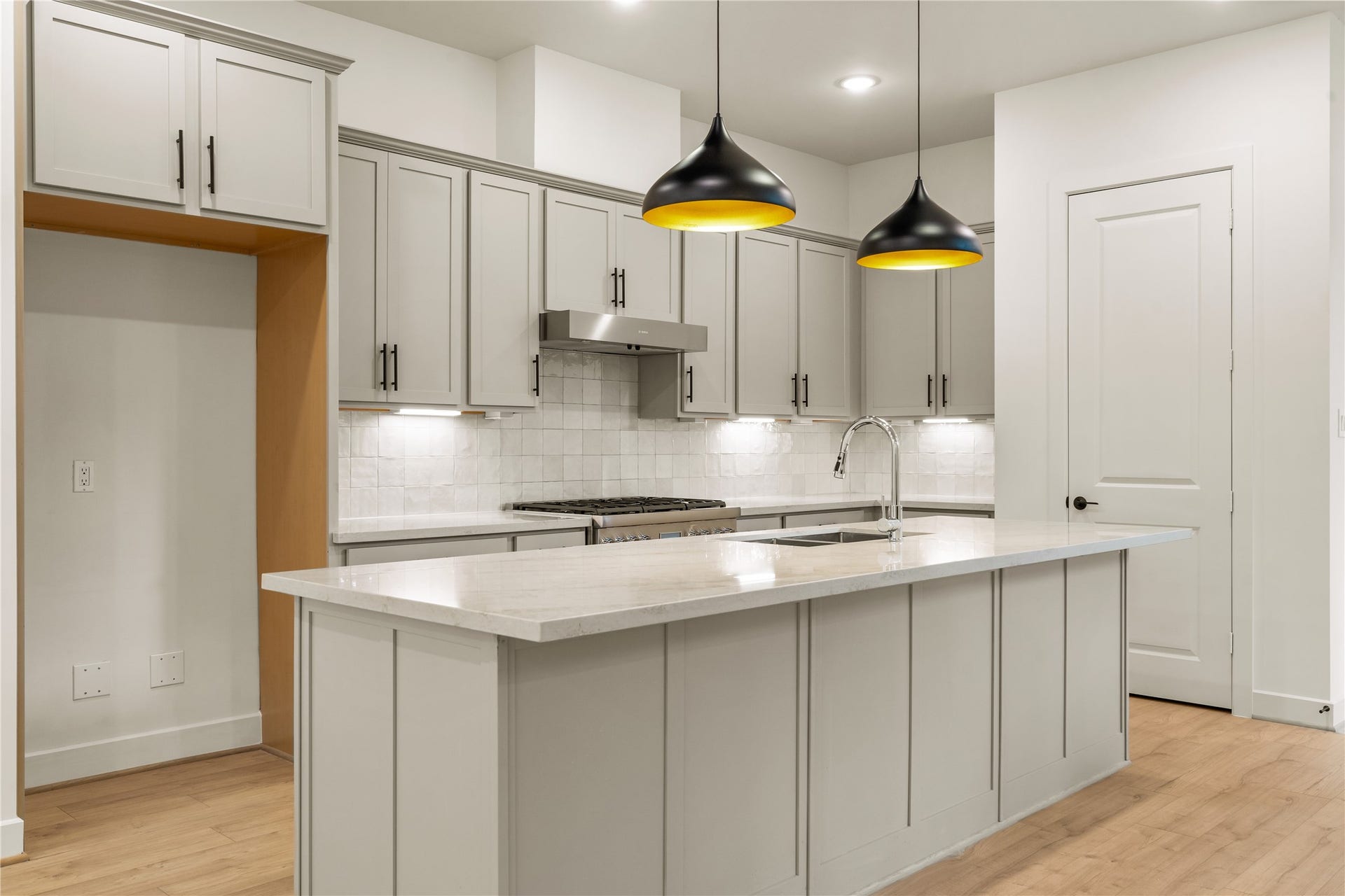 5016 Schuler Street, Houston, TX 77007 Gourmet workspace layout sleek gooseneck faucet, warm light-wood flooring, and custom cabinetry with dedicated refrigerator alcove.