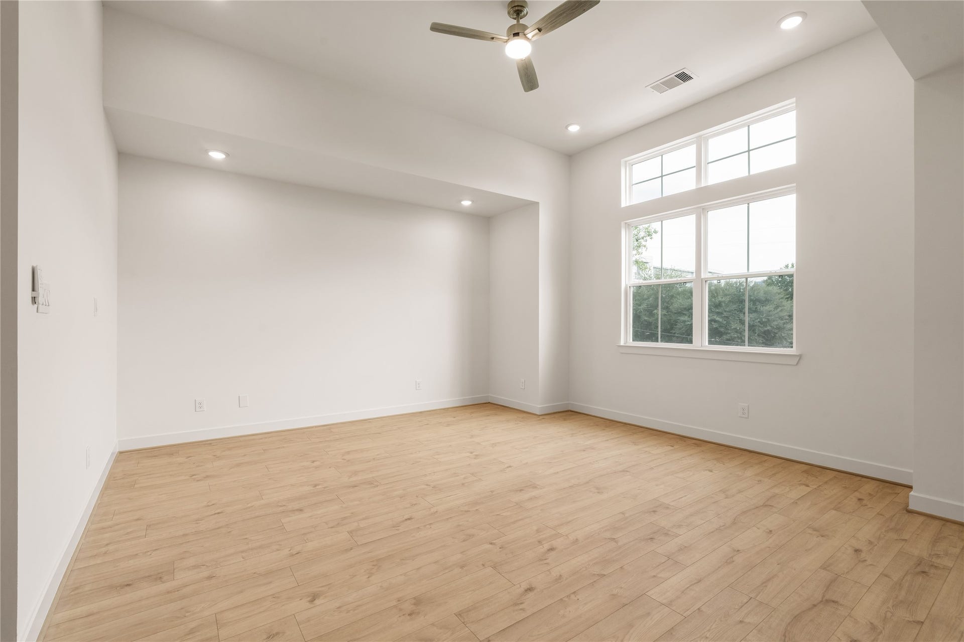 5016 Schuler Street, Houston, TX 77007 Primary bedroom sanctuary soaring high ceiling with transom windows streaming morning light, recessed lighting, and modern ceiling fan.