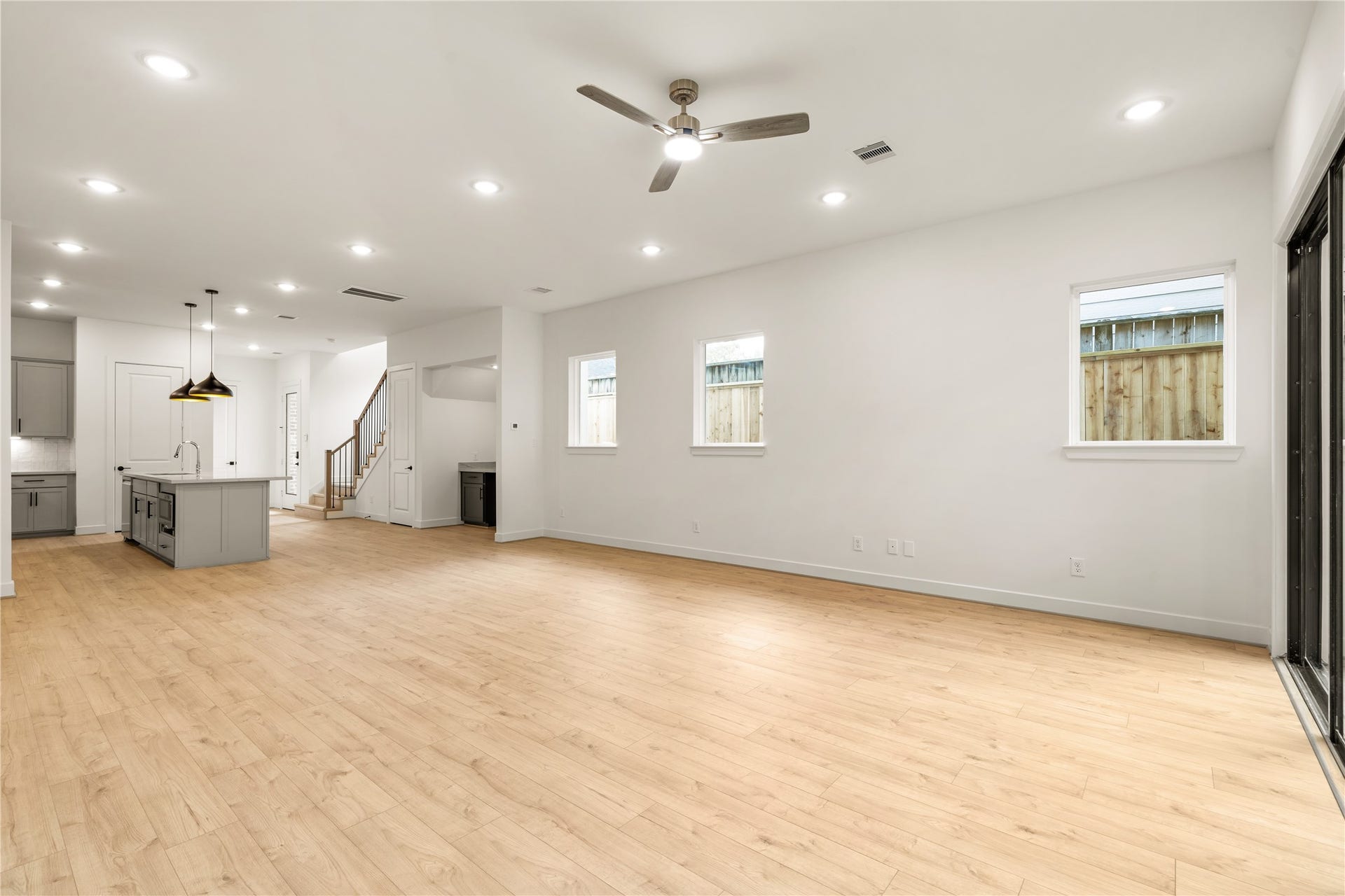 5016 Schuler Street, Houston, TX 77007 Generous living hall perspective bright neutral walls, side-yard accent windows, and clear sightlines to the stairwell and kitchen hub.
