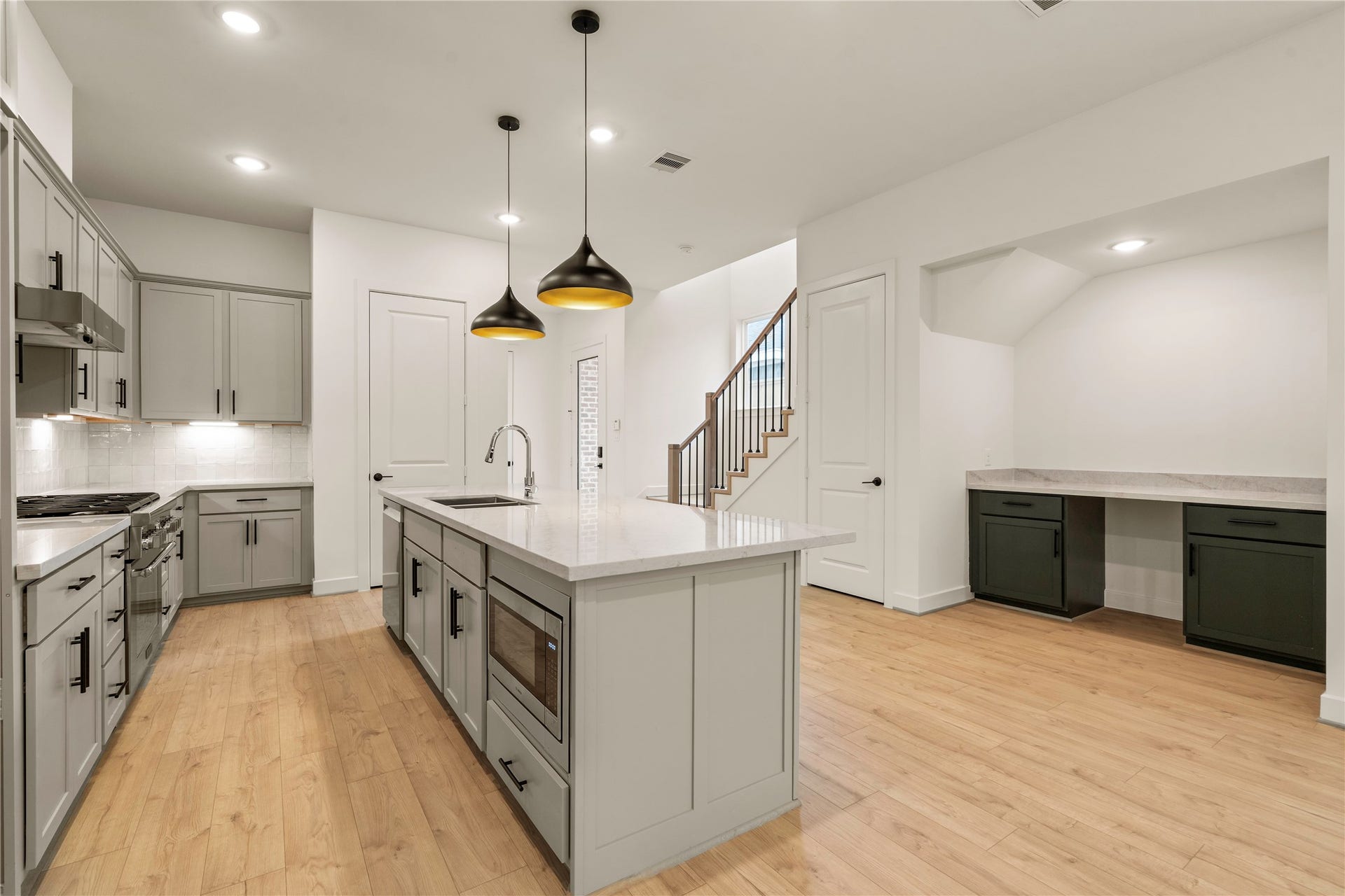 5016 Schuler Street, Houston, TX 77007 Functional design features island microwave drawer inset, stainless steel appliance package, and custom built-in workstation nook tucked neatly under the staircase.