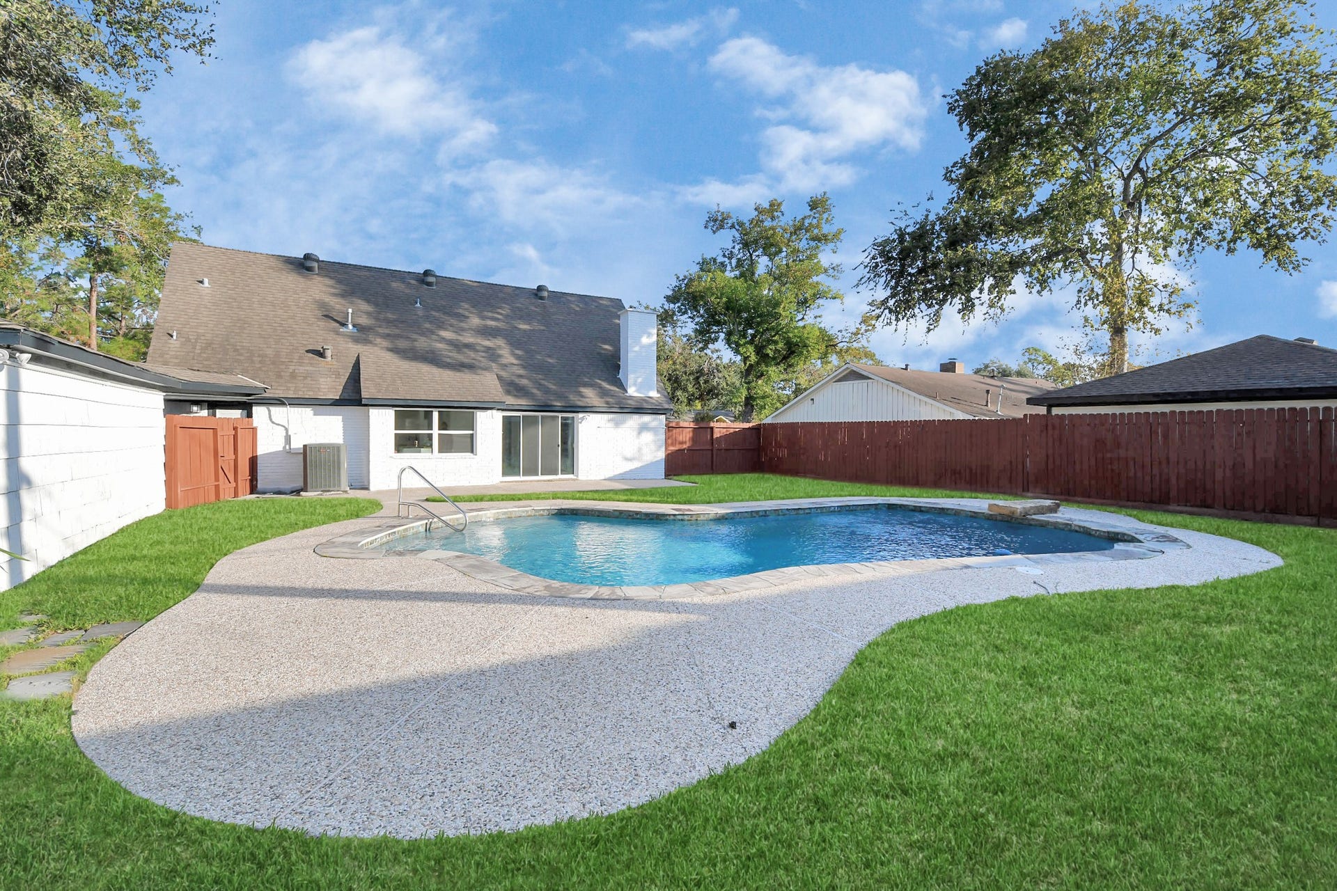 6035 Cartagena Street, Houston, TX 77035 A paved area alongside the pool provides the perfect spot for lounge chairs, inviting you to relax and soak up the sun.