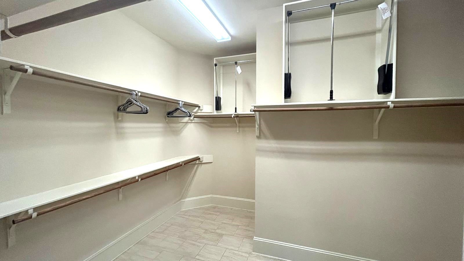 Stunning, oversized primary closet with custom shelving