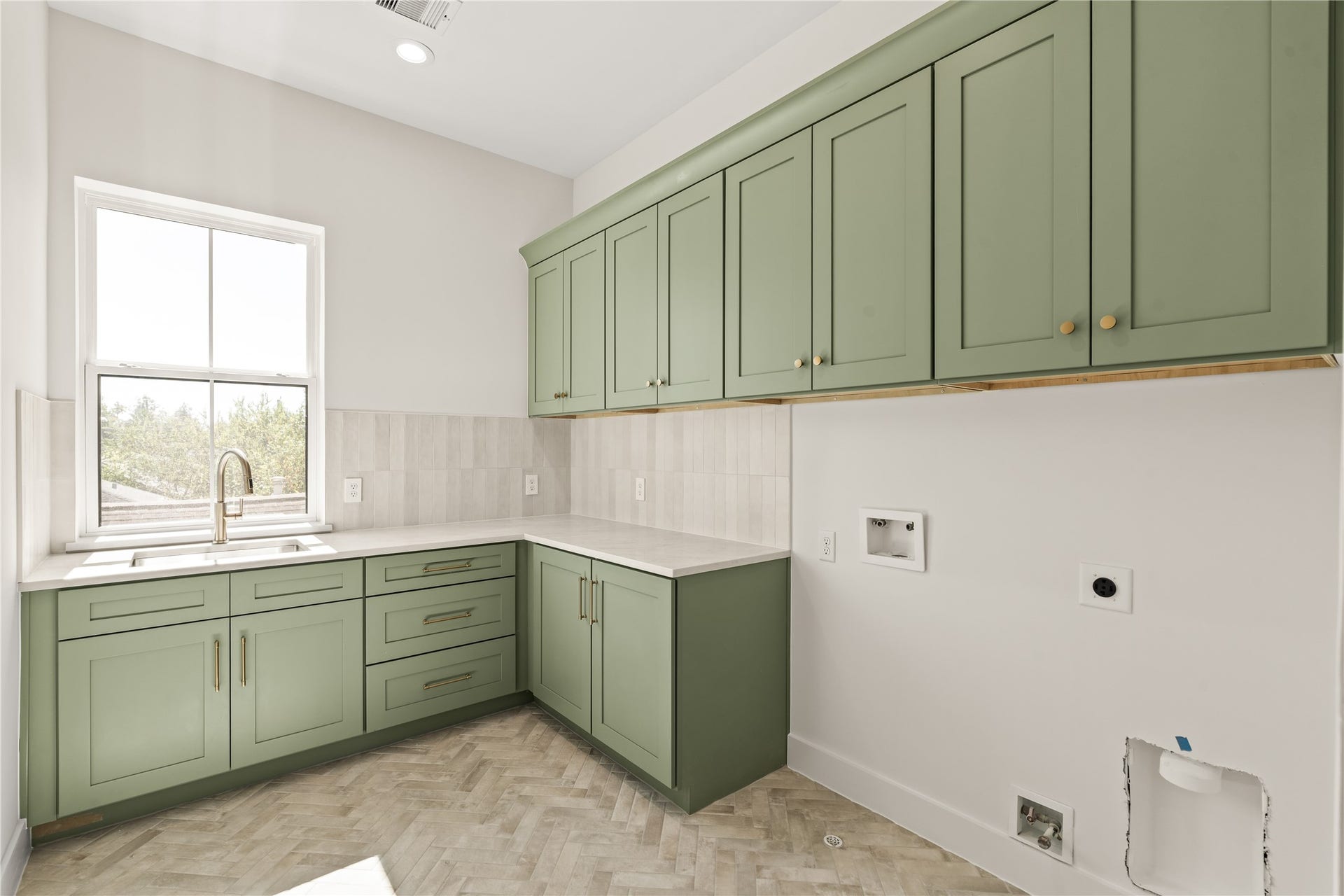 2011 Singleton Street, Houston, TX 77008 Utility room with chevron flooring, sink, and cute sage green cabinets.