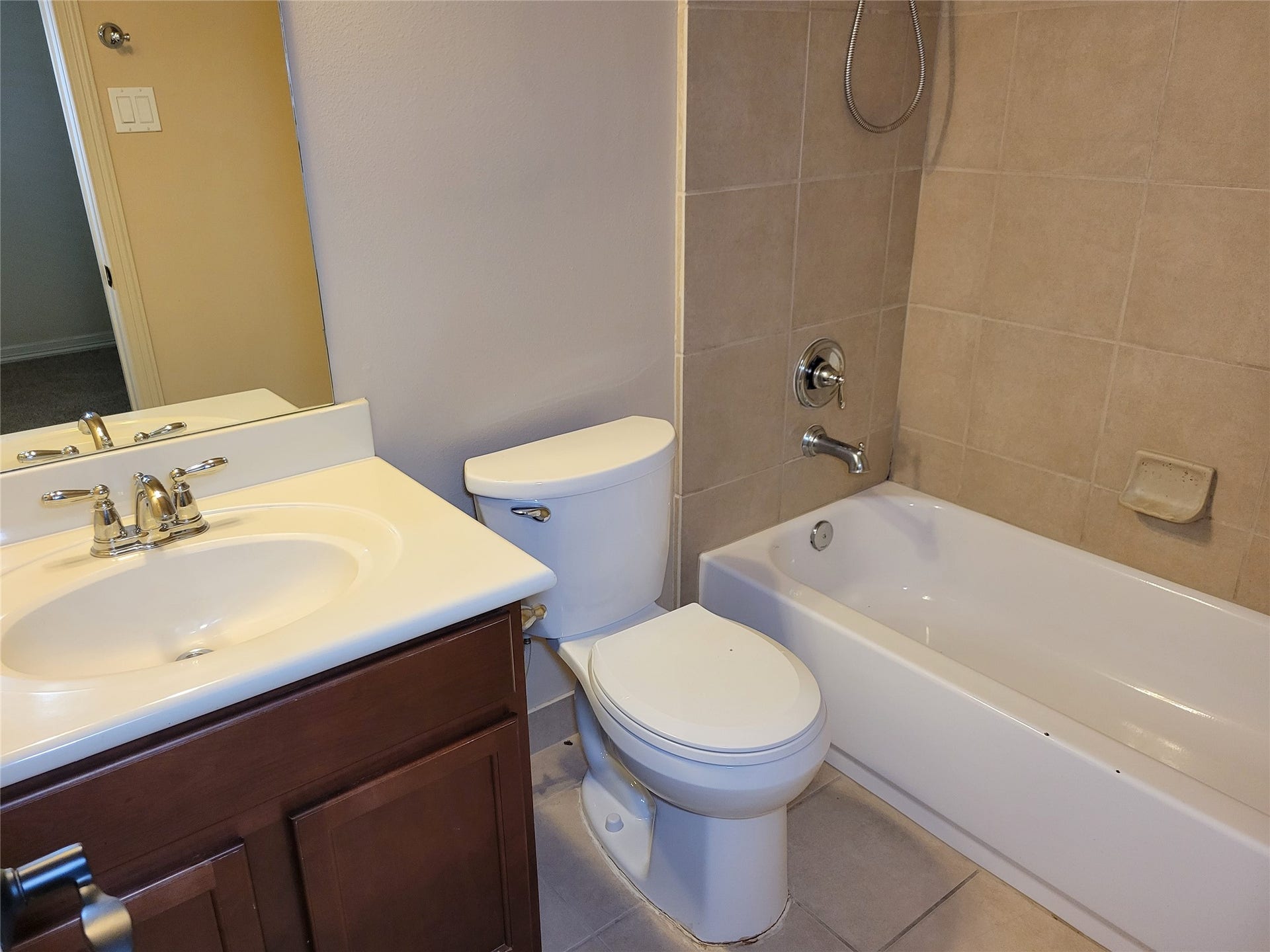 2210 Pearl Bay Court, Pearland, TX 77584 This bathroom features a clean and modern design with a white sink and countertop, a toilet, and a bathtub with tiled walls. The neutral tones create a fresh and inviting atmosphere.