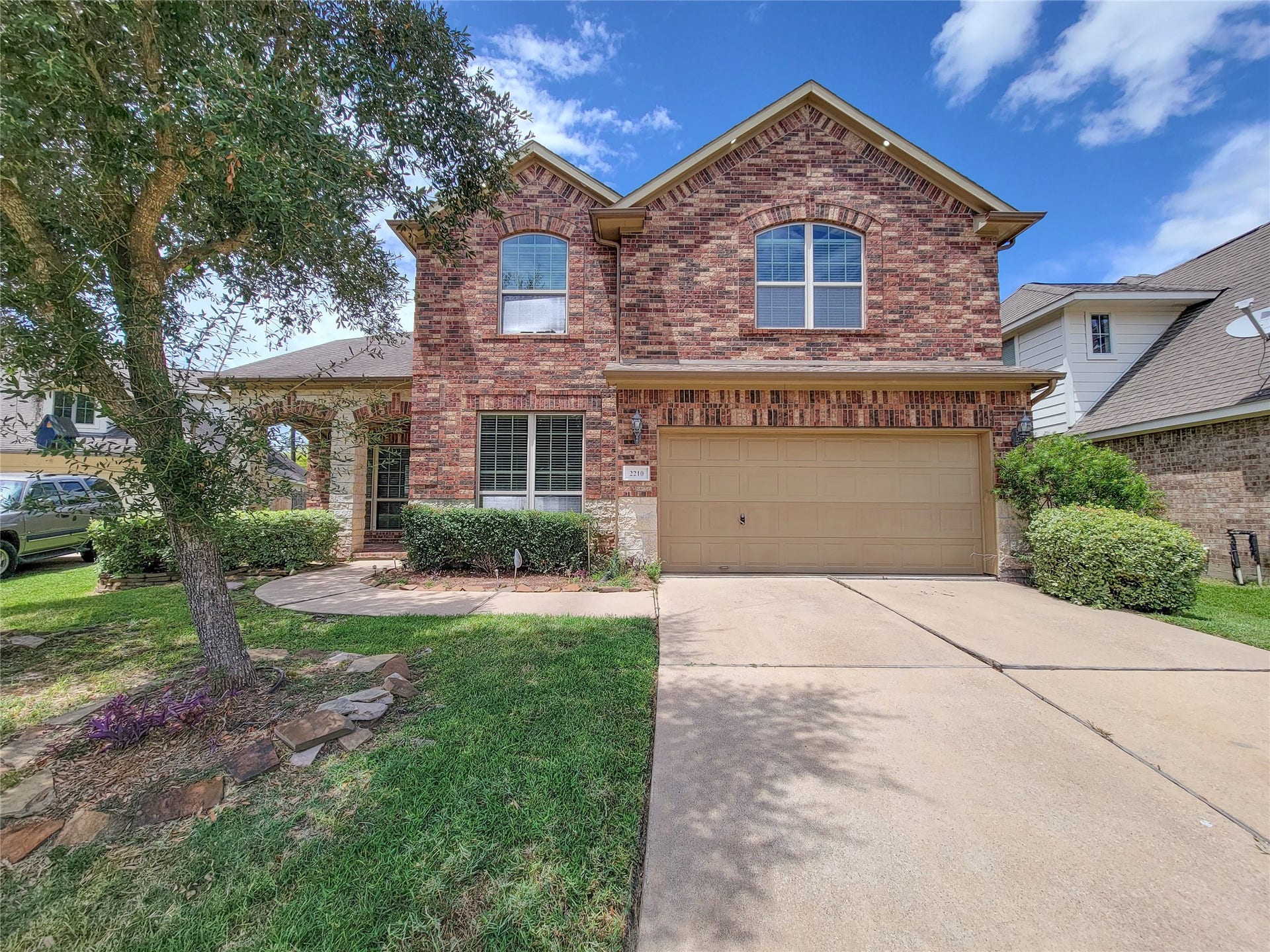 2210 Pearl Bay Court, Pearland, TX 77584 This charming two-story brick home features a double garage, well-maintained lawn, and mature tree in the front yard. Ideal for families, it offers a welcoming exterior and a spacious driveway.