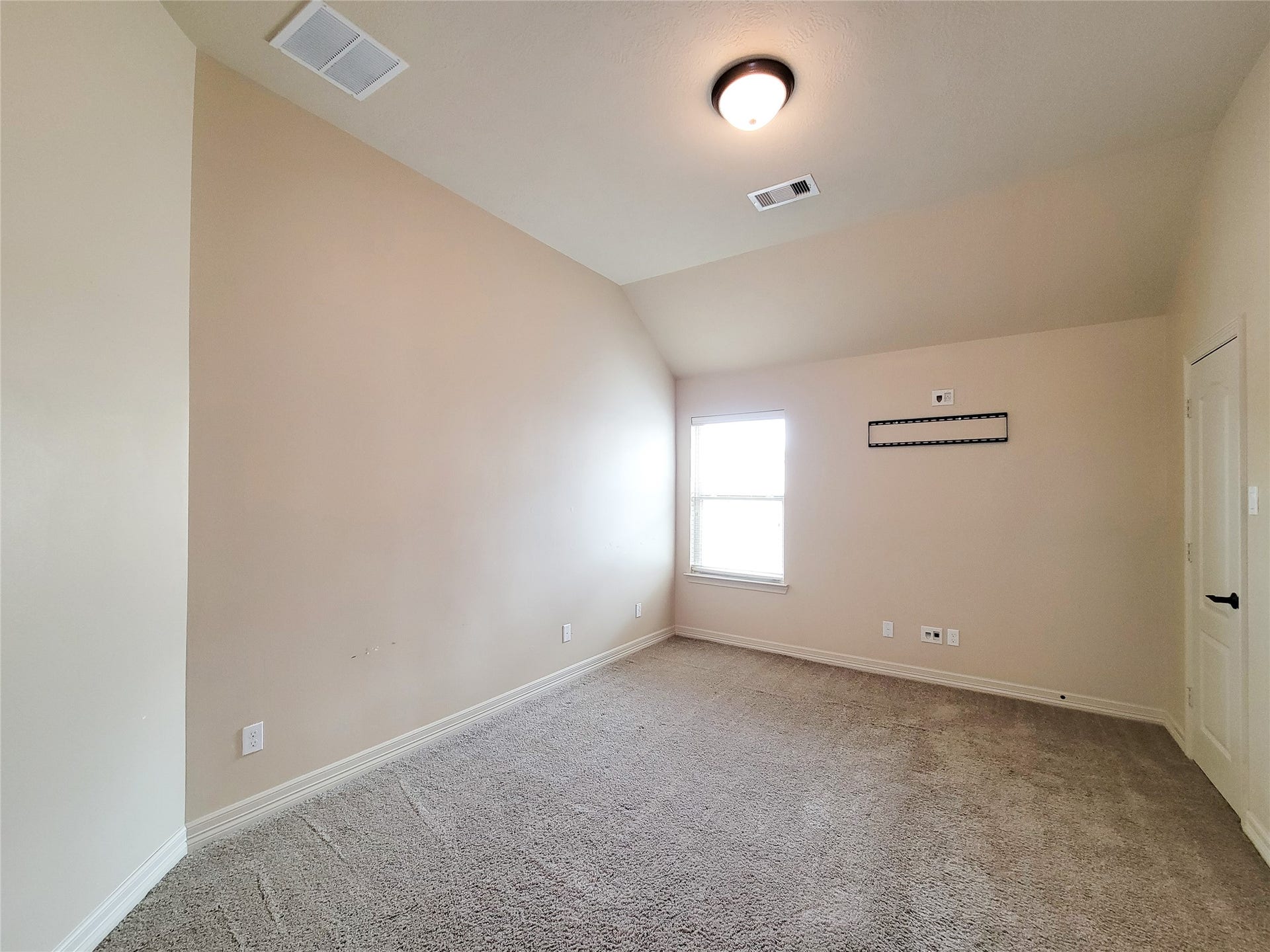 2210 Pearl Bay Court, Pearland, TX 77584 This room features neutral walls, plush carpet, a single window providing natural light, and a ceiling light fixture. It's ideal for a bedroom or home office, with a wall mount for a TV or monitor.