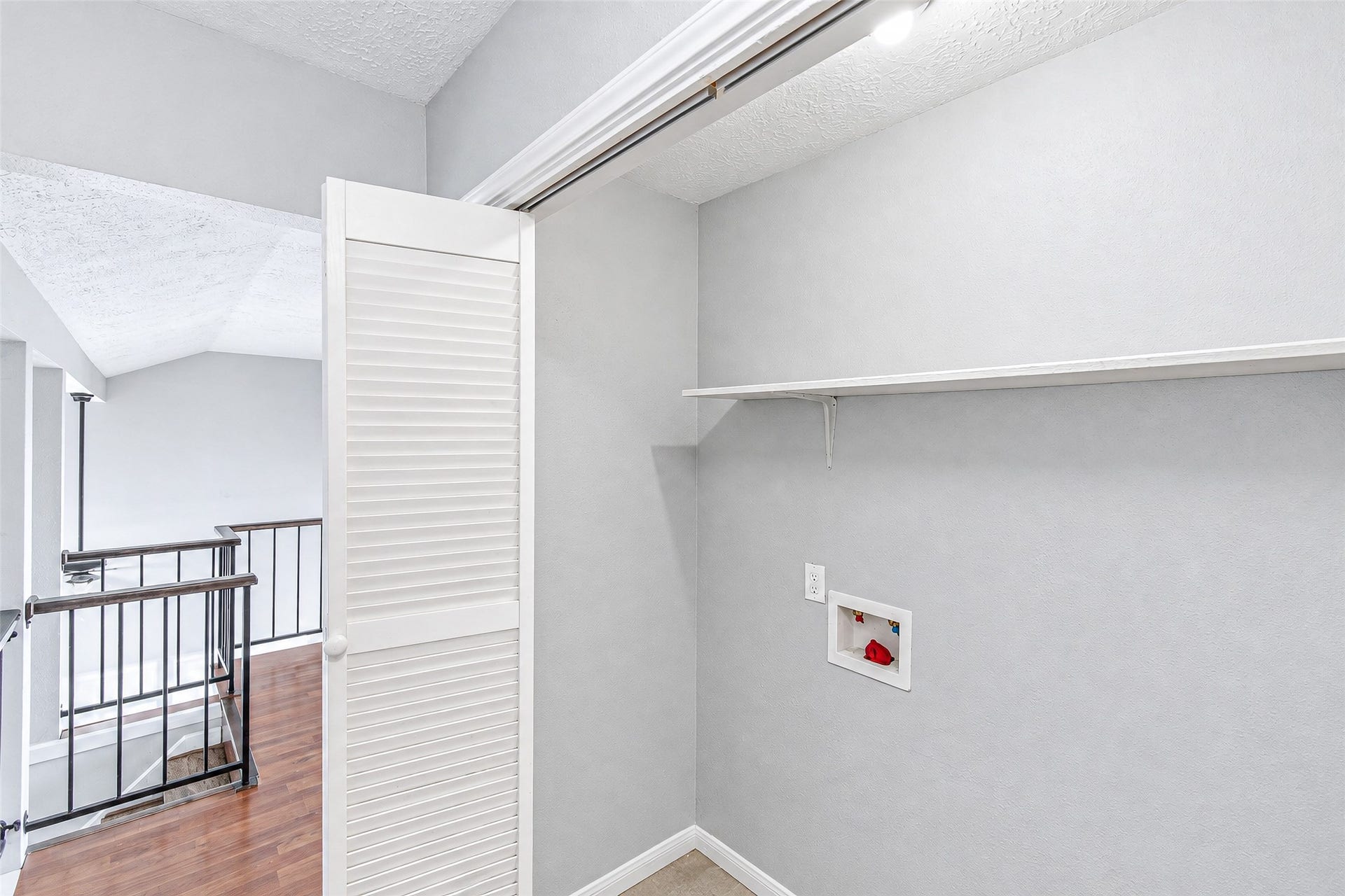 12027 Huntington Park Drive, Houston, TX 77099 Convenient laundry nook with built-in shelving, located next to a stylish railing overlooking the lower level.