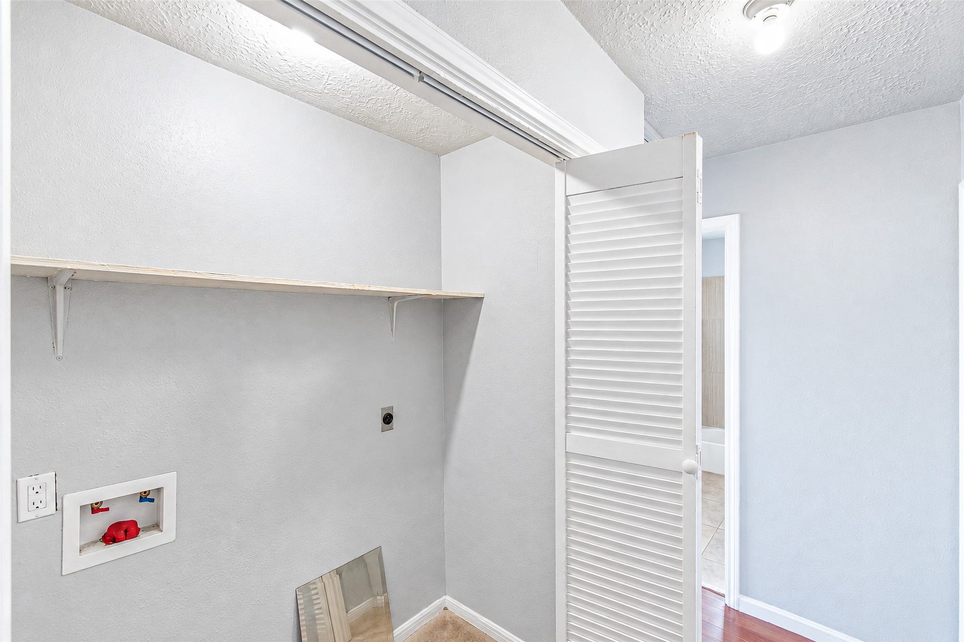 12027 Huntington Park Drive, Houston, TX 77099 Compact laundry nook with built-in shelving, ready for your washer and dryer setup.
