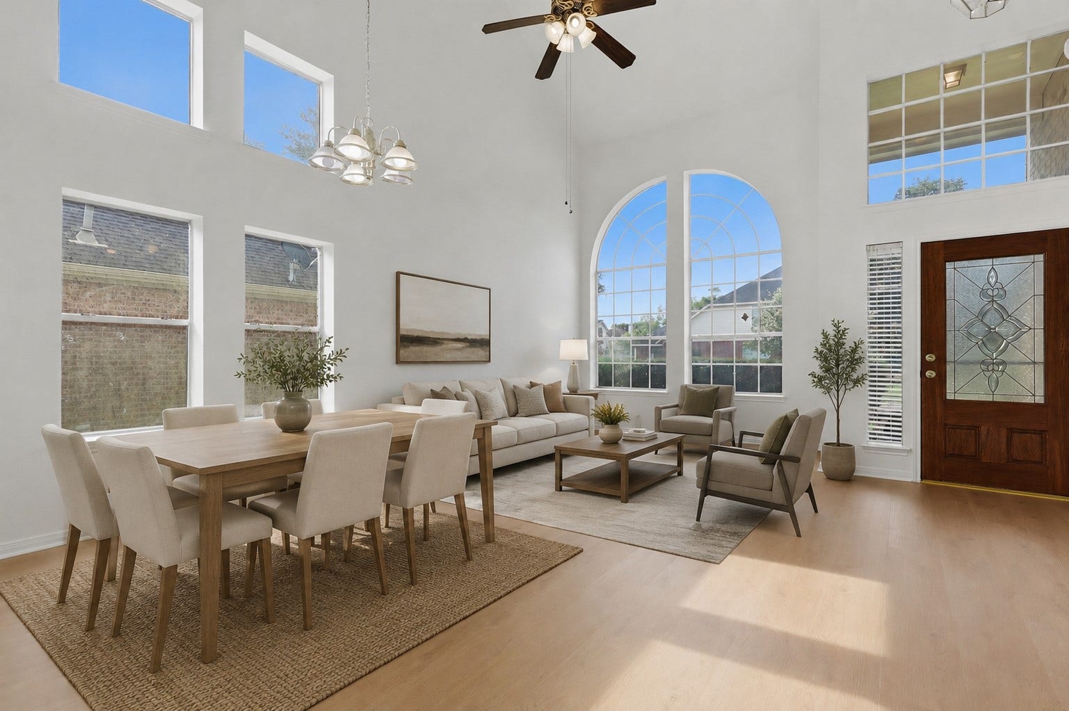 16622 Stoneside Drive, Houston, TX 77095 A decorative glass-paneled door reveals an airy living room highlighted by double-height ceilings and expansive arched windows.**Virtually staged