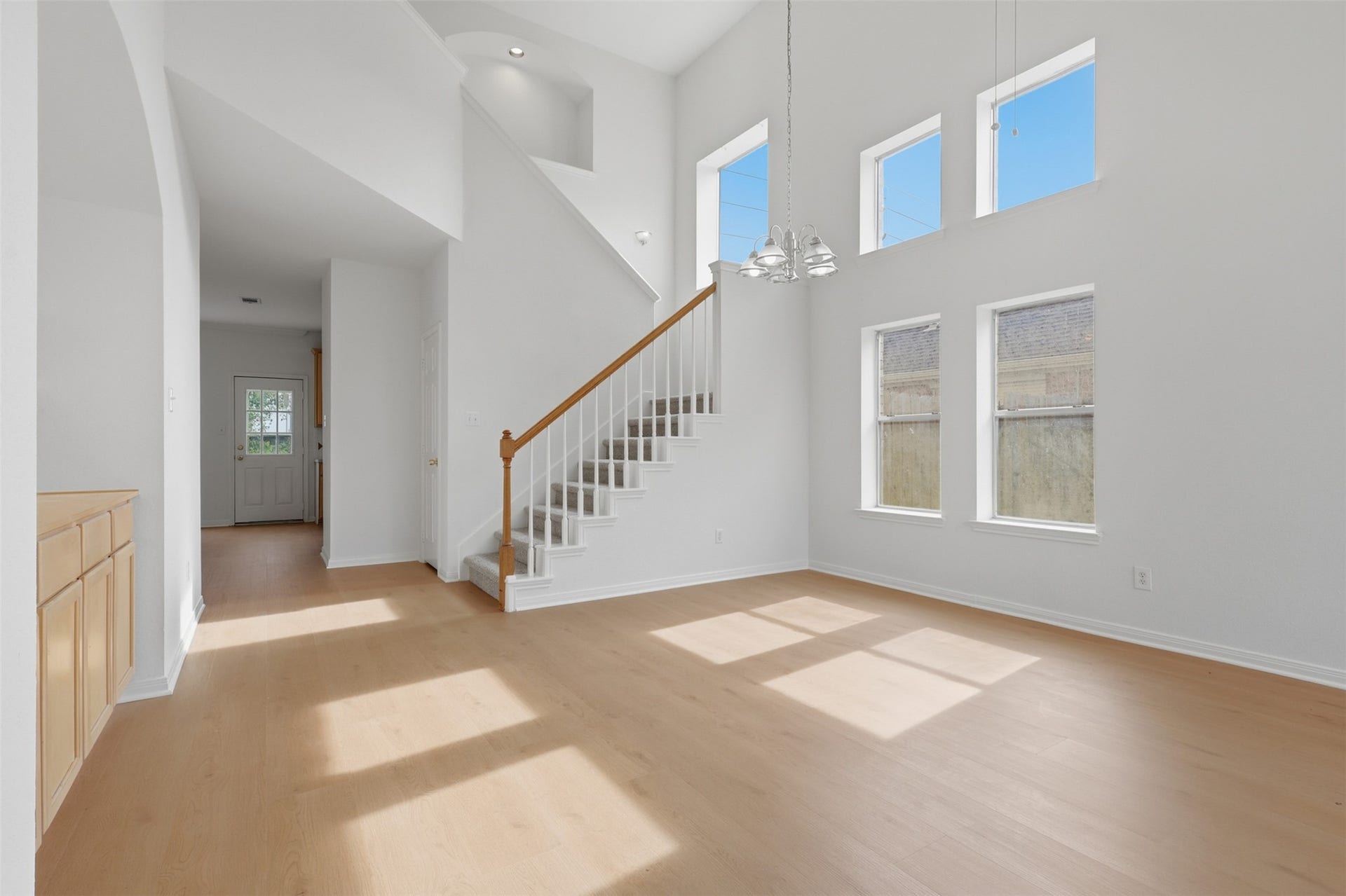 16622 Stoneside Drive, Houston, TX 77095 A sprawling main level connects to the upper loft via a traditional staircase featuring stained hardwood handrails, accented by elegant chandeliers.