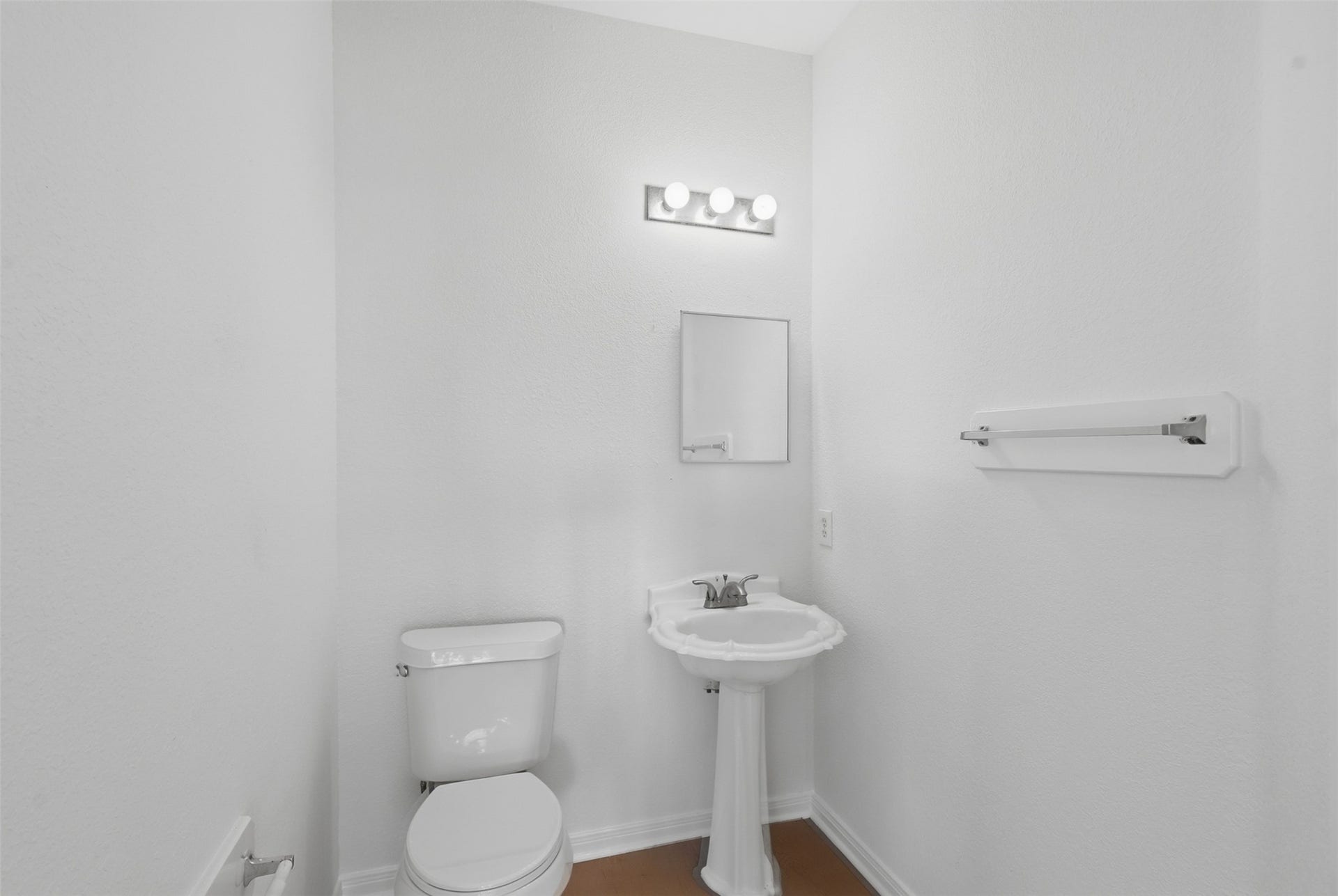 16622 Stoneside Drive, Houston, TX 77095 The convenient half-bath is equipped with a traditional porcelain pedestal basin, vanity bar globes, and a wall-mounted towel rod.
