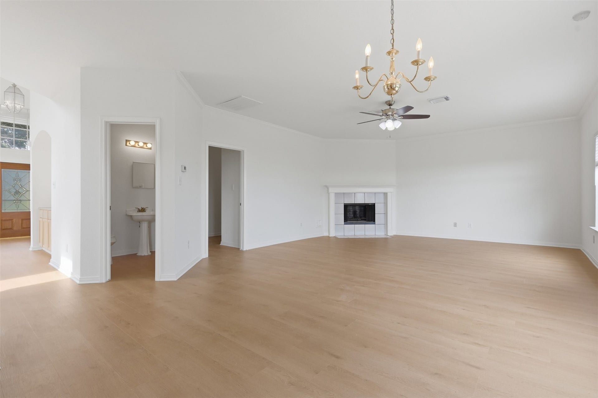 16622 Stoneside Drive, Houston, TX 77095 An ornate golden chandelier accents this expansive great room, which features continuous light plank flooring and a corner tile fireplace.