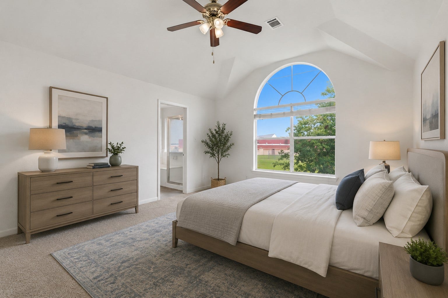 16622 Stoneside Drive, Houston, TX 77095 This primary bedroom showcases a deep arched window framing green outdoor views, paired with direct access to the en suite bathroom.**Virtually staged