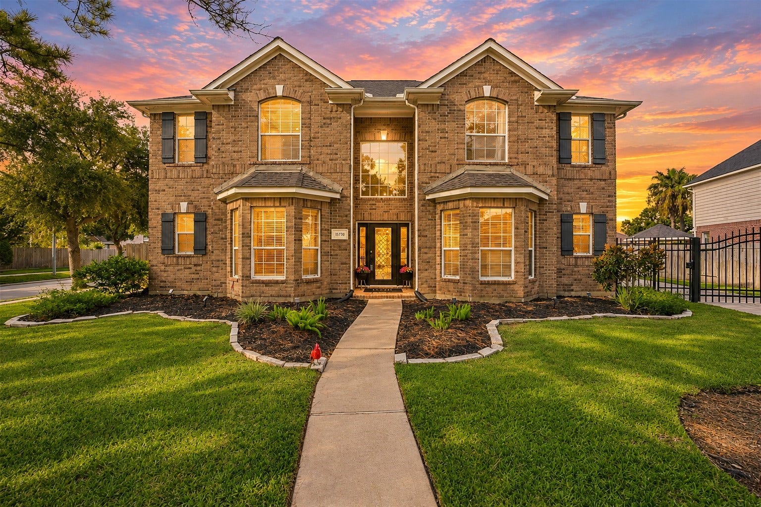 15730 Lake Loop Drive, Cypress, TX 77433 Stately two-story brick home with elegant bay windows, manicured landscaping, and a welcoming pathway leading to the front entrance.