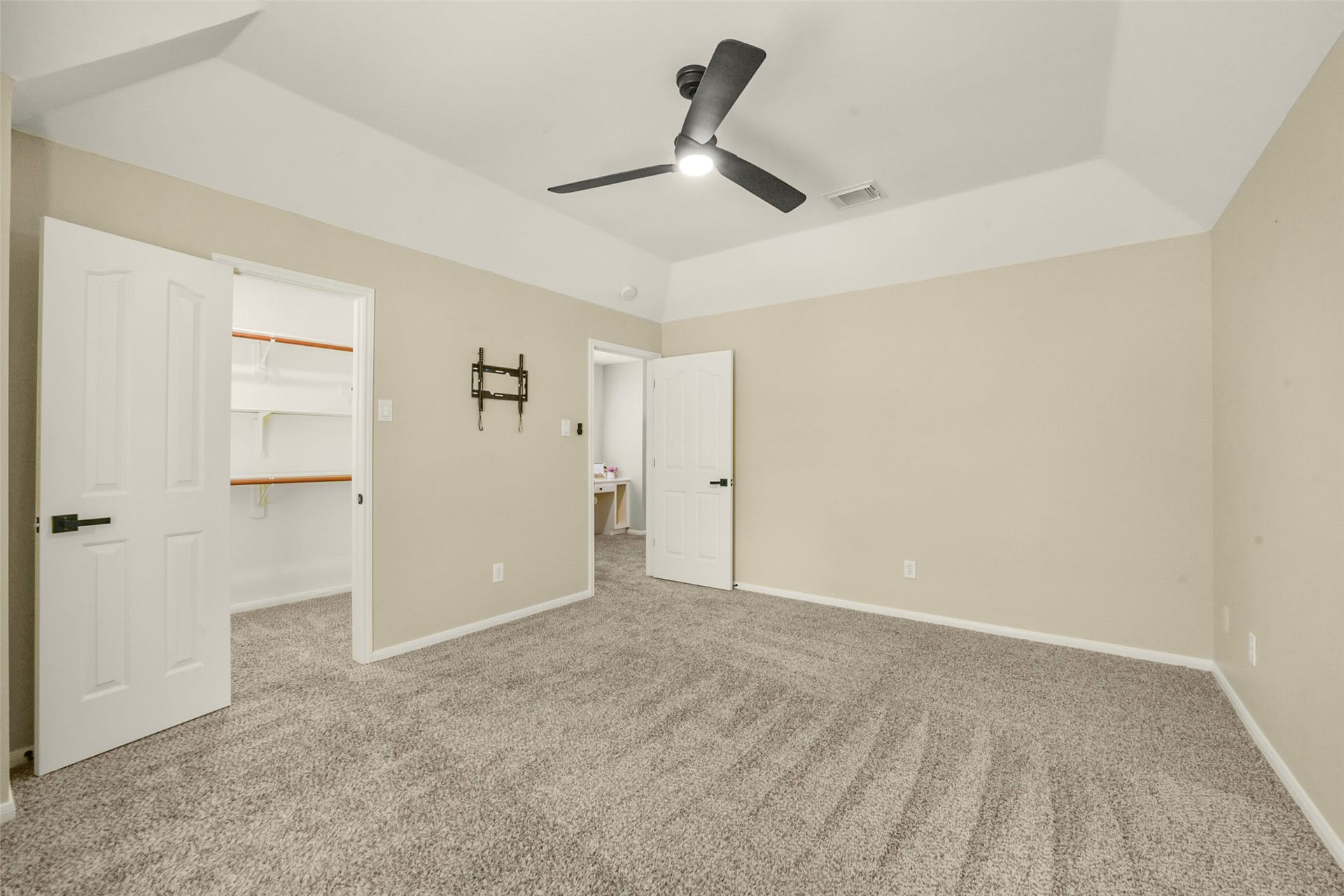 15730 Lake Loop Drive, Cypress, TX 77433 Spacious bedroom featuring plush carpet, a ceiling fan, and ample natural light, with convenient access to a walk-in closet.