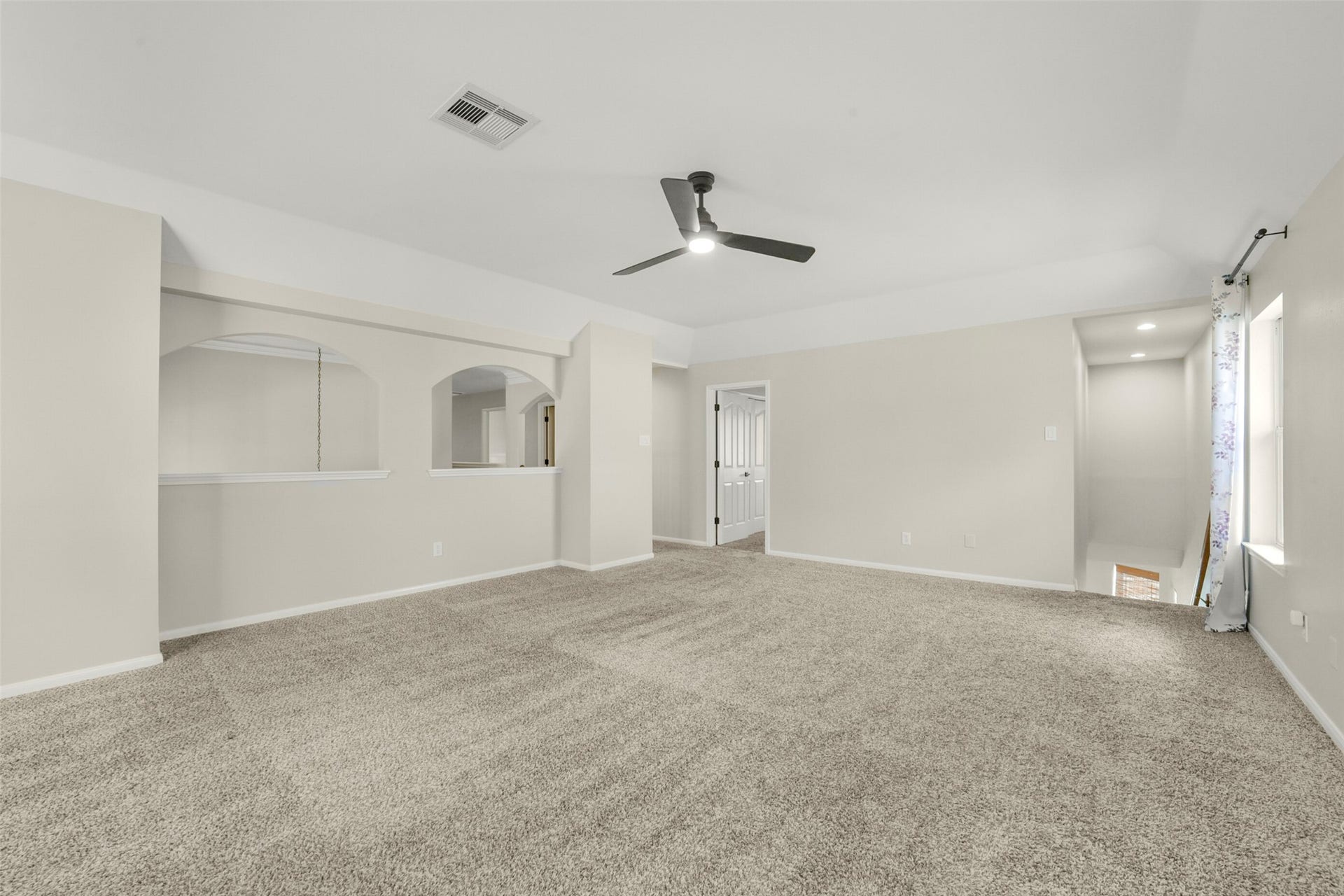 15730 Lake Loop Drive, Cypress, TX 77433 Spacious living area with plush carpeting, neutral tones, and a ceiling fan, offering a cozy and inviting atmosphere.