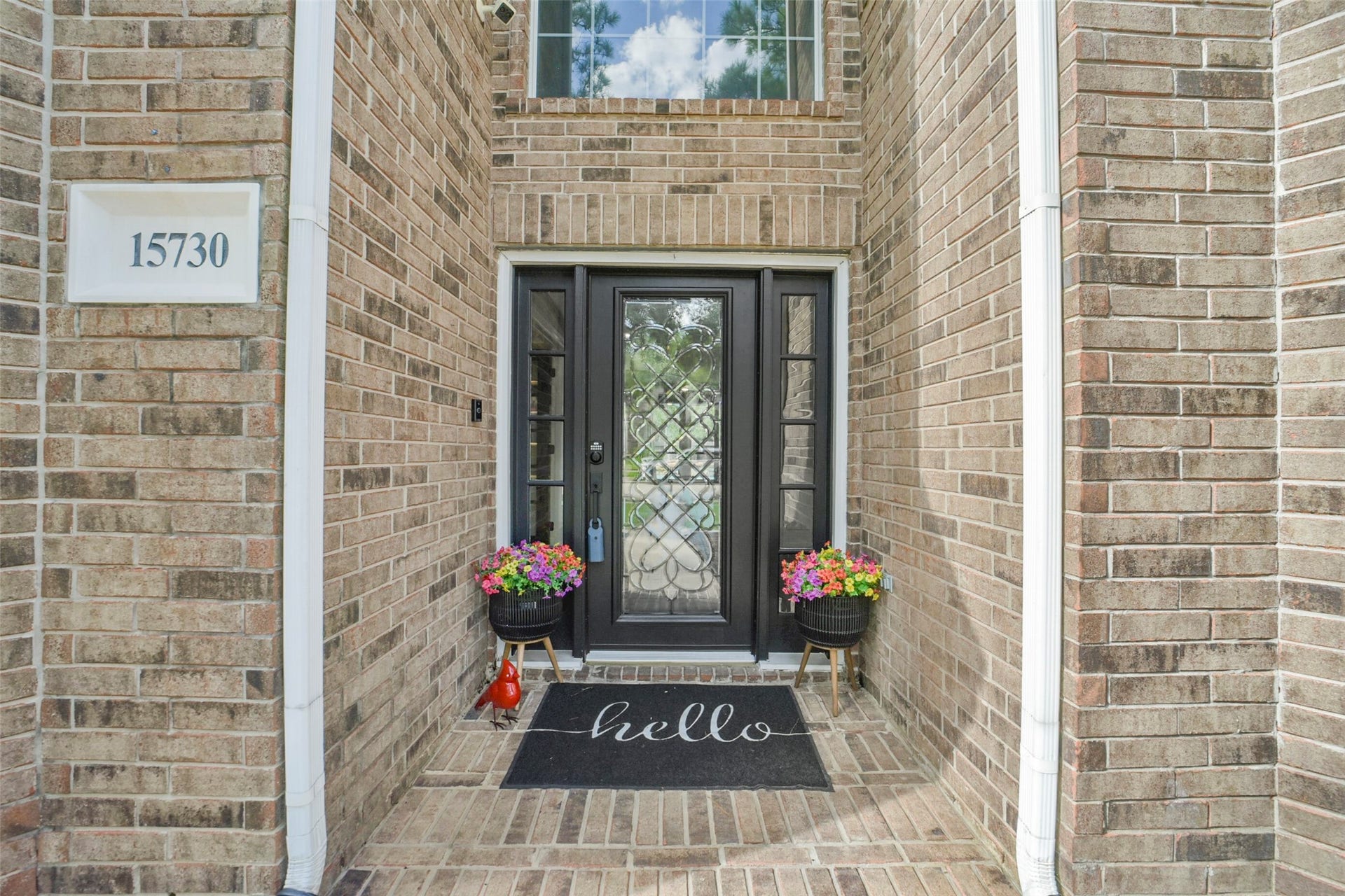 15730 Lake Loop Drive, Cypress, TX 77433 Charming brick entryway featuring a stylish black door with decorative glass panels.