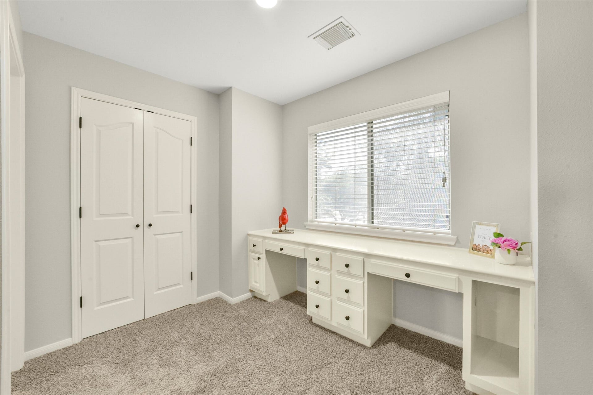 15730 Lake Loop Drive, Cypress, TX 77433 Bright and inviting workspace featuring a built-in desk with ample storage, plush carpeting, and a large window for natural light.