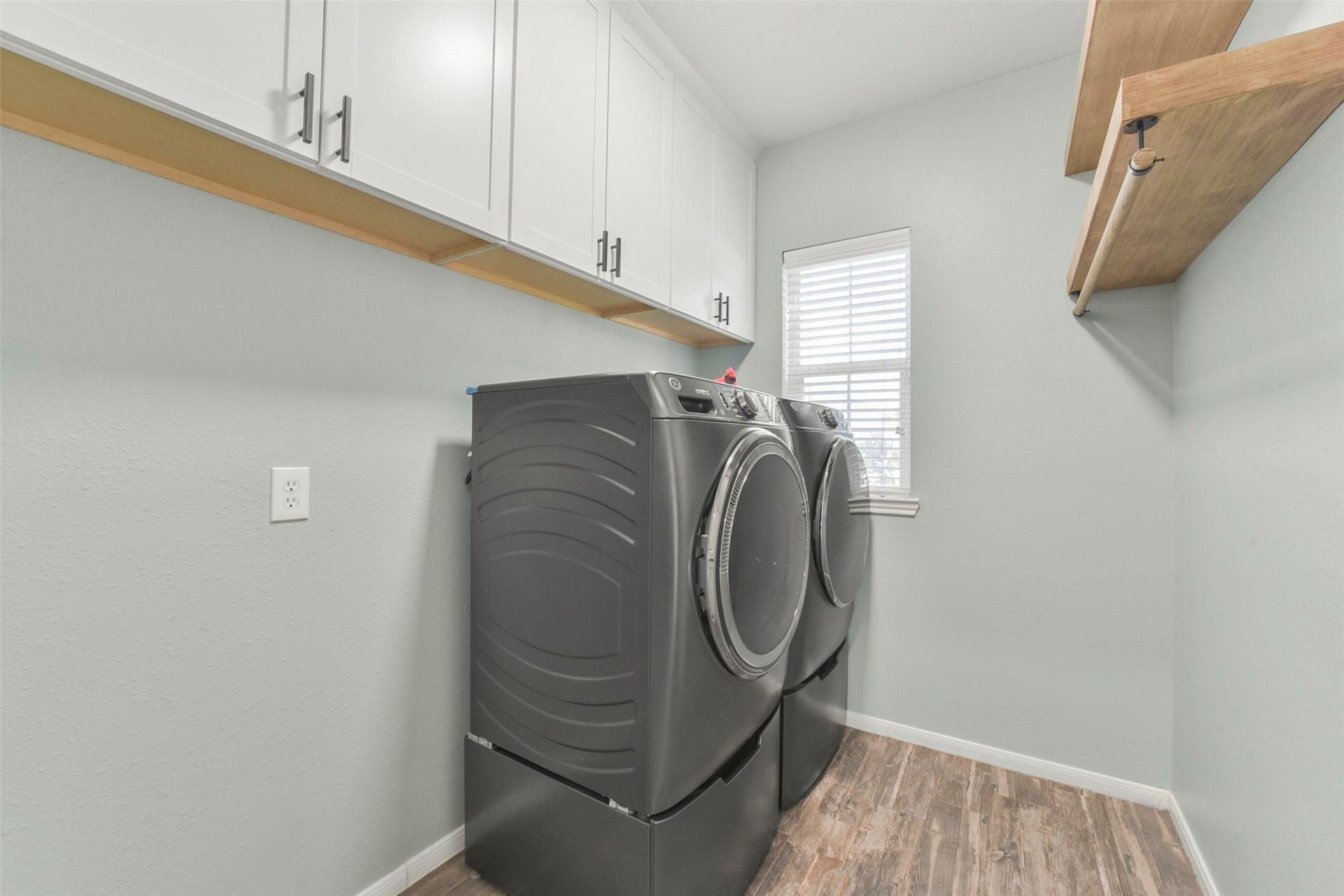 15730 Lake Loop Drive, Cypress, TX 77433 Sleek and functional laundry room with modern appliances, ample cabinetry, and a convenient shelf for additional storage.