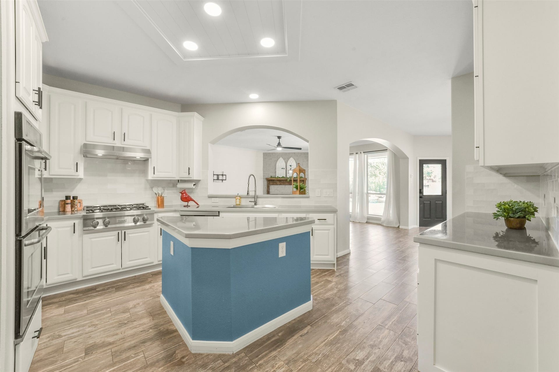 15730 Lake Loop Drive, Cypress, TX 77433 Spacious kitchen featuring sleek white cabinetry, modern appliances, and elegant countertops, accented by warm wood flooring