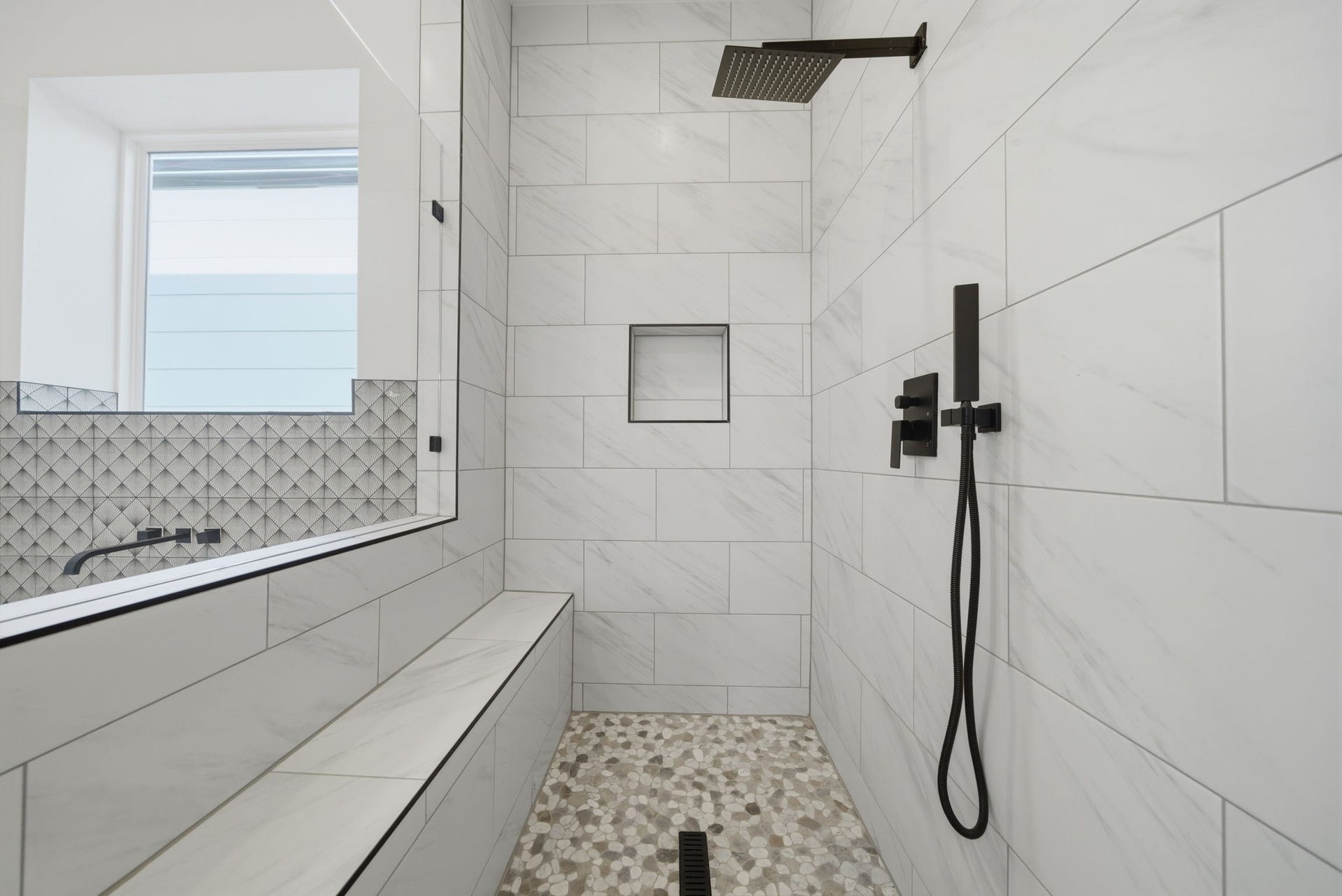 Spa-like primary bath features dual shower heads, shower seat, and tile extending to the ceiling. (Photos are of a previously completed home. Finishes are subject to change.)