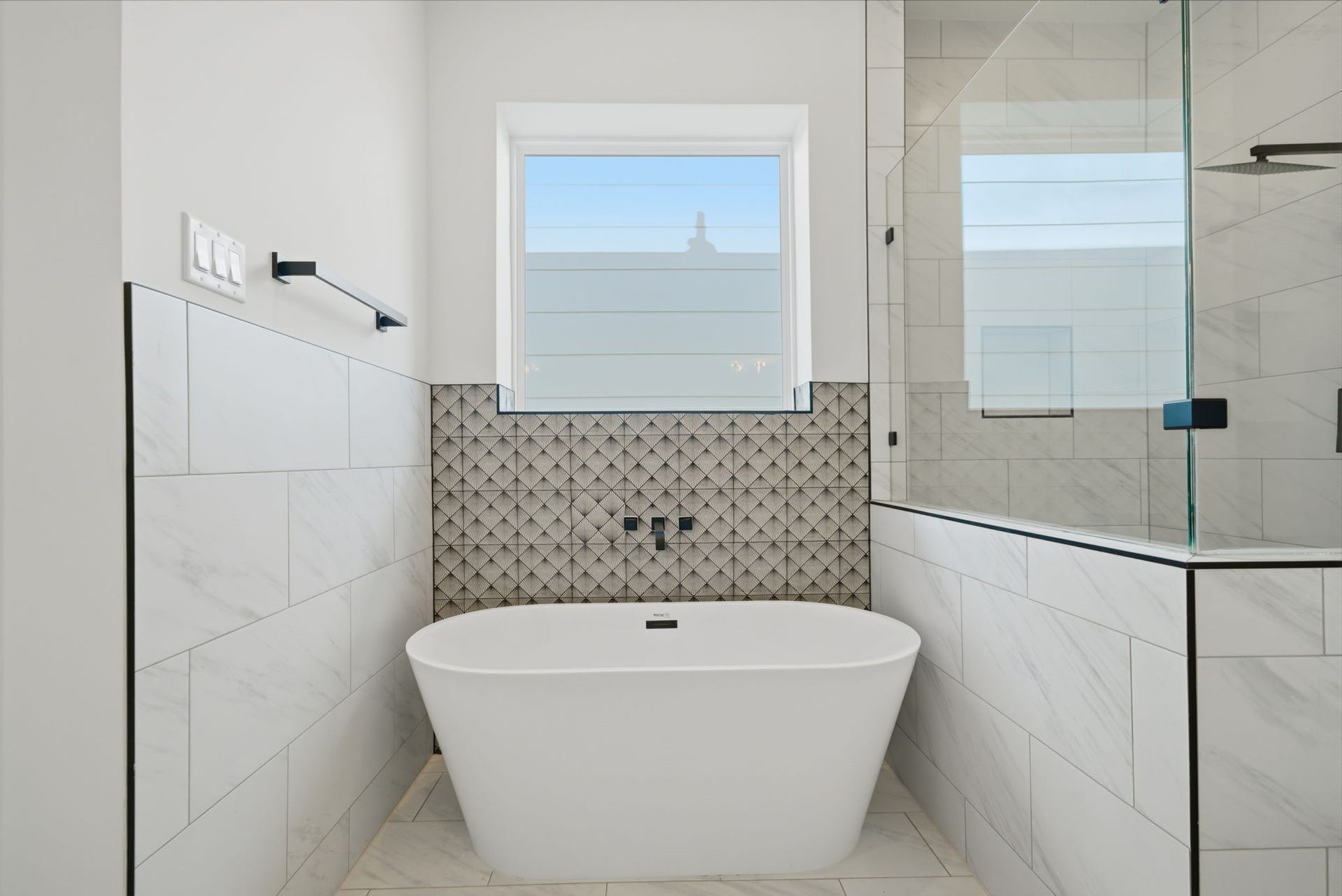 Lovely freestanding soaking tub with decorative tile. (Photos are of a previously completed home. Finishes are subject to change.)