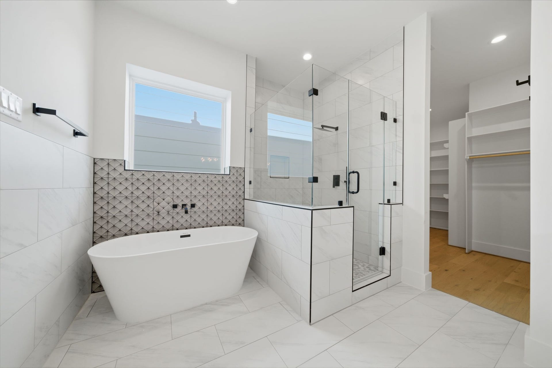 Stylish primary bath with high-end finishes and a freestanding soaking tub. (Photos are of a previously completed home. Finishes are subject to change.)