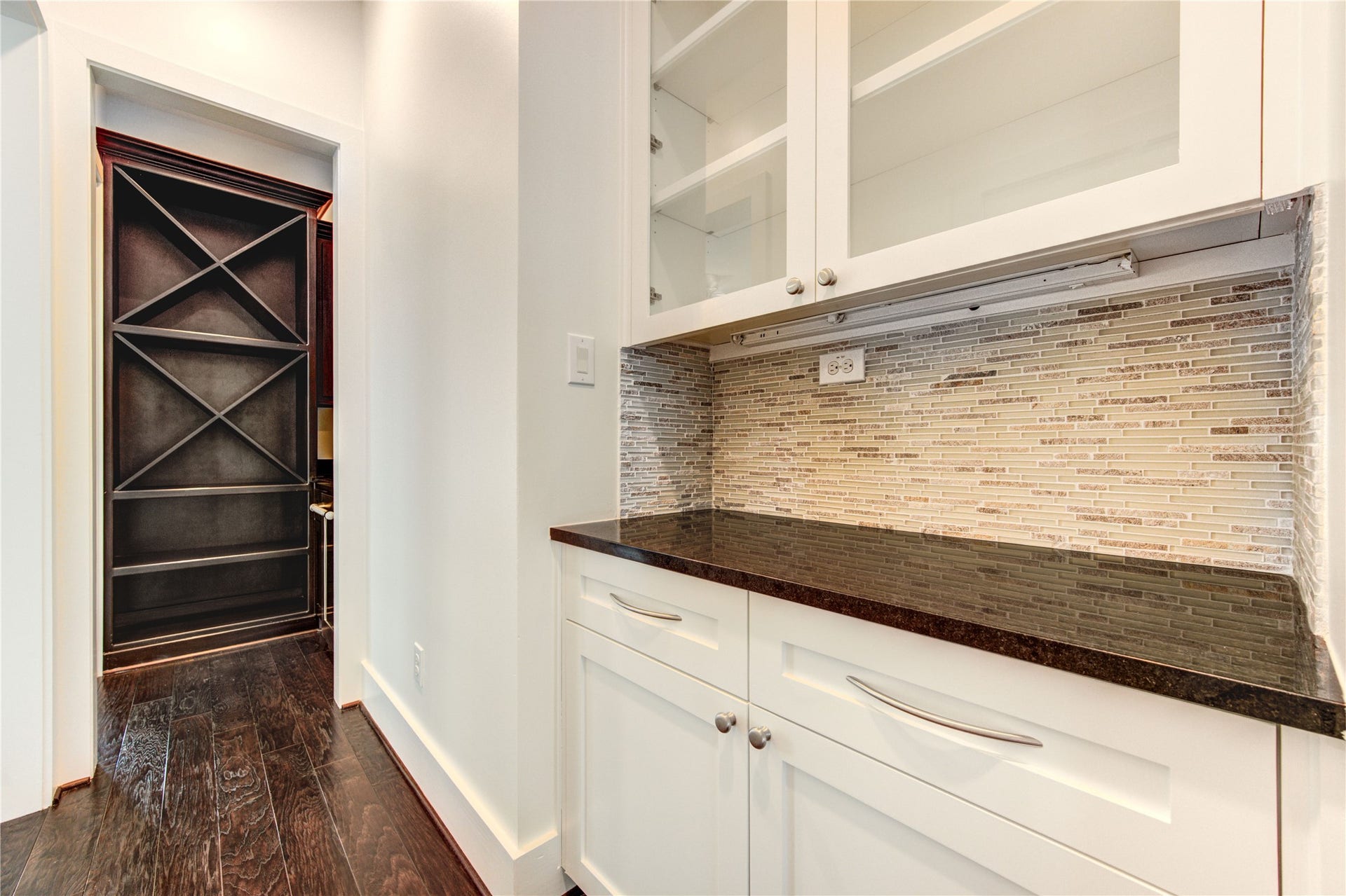 The butler's pantry and adjoining wine room create an elegant connection between the kitchen, formal dining room and main living area- designed for effortless entertaining.