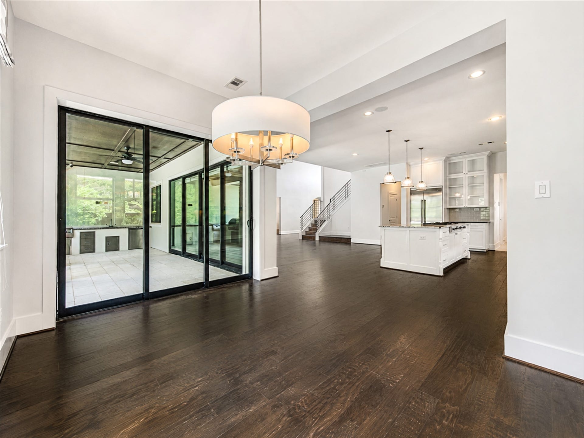 Effortless flow connects the breakfast area, chef's kitchen and covered patio, showcasing the home's exceptional open-concept and indoor-outdoor design.