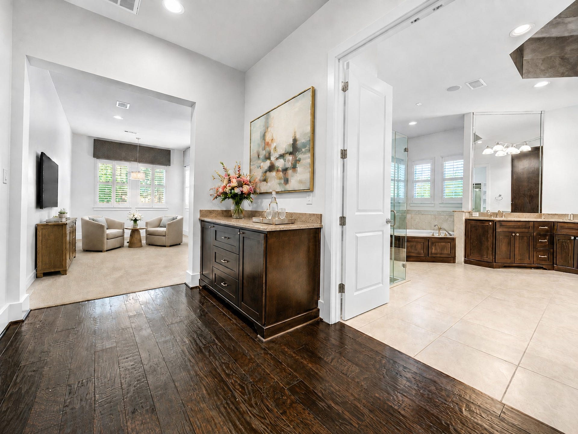 The primary suite opens to a gracious private foyer, with the spa-inspired bath to the right and the expansive bedroom just beyond. Digitally staged.
