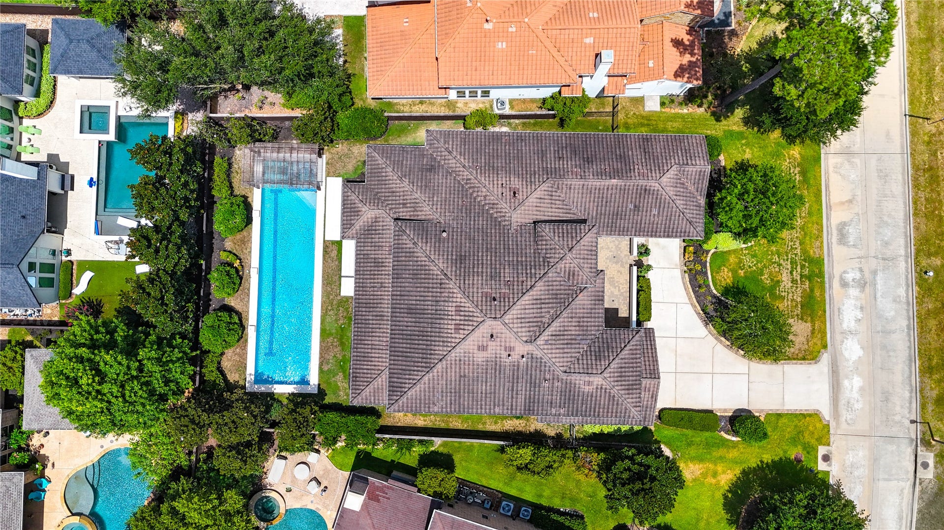 This bird's-eye view highlights the home's impressive footprint, expansive lap-style pool and distinctive 3-car garage configuration with a separate single-car bay.